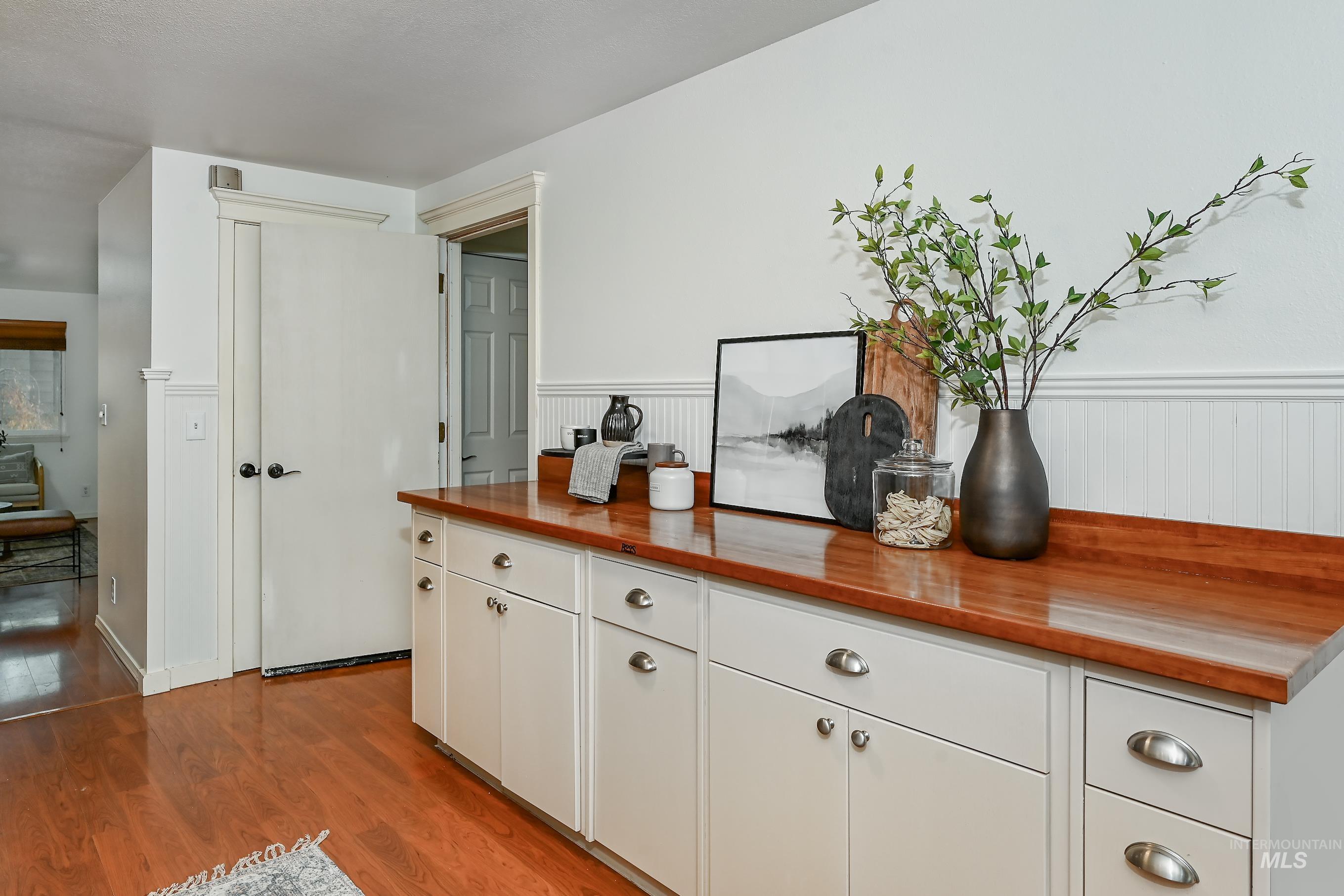 Detailed view of wood finished floors and a wainscoted wall