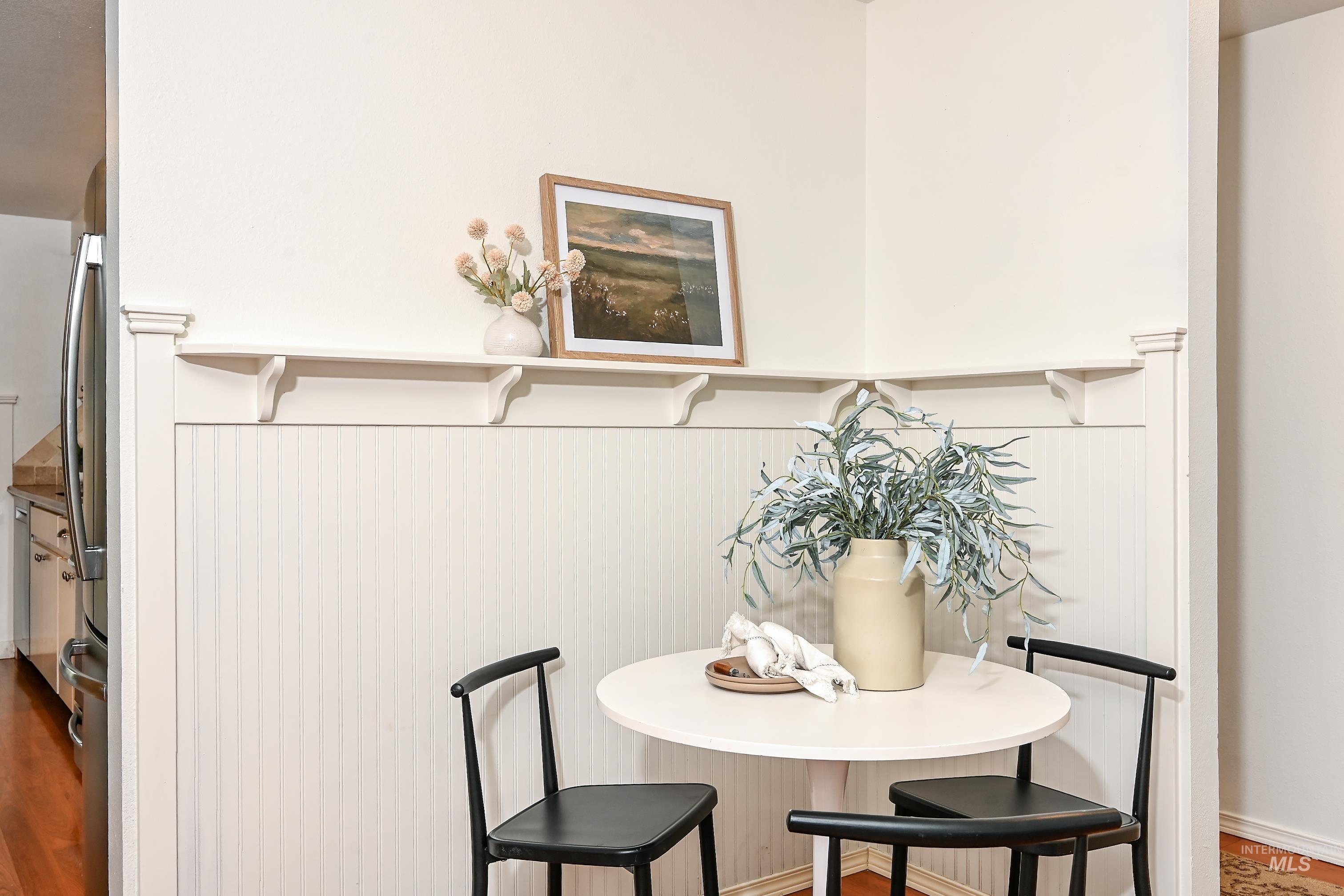 Detailed view of freestanding refrigerator and wood finished floors