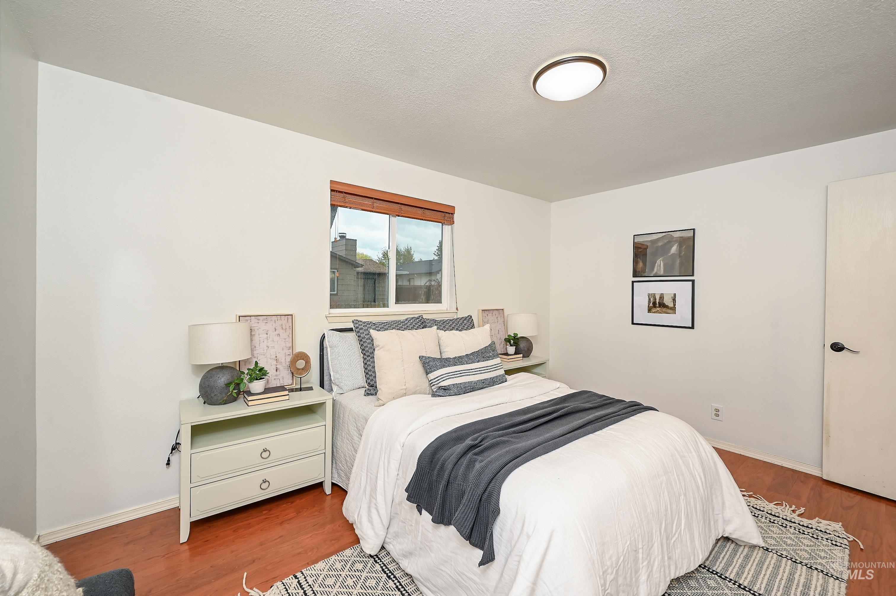 Bedroom featuring wood finished floors and a textured ceiling