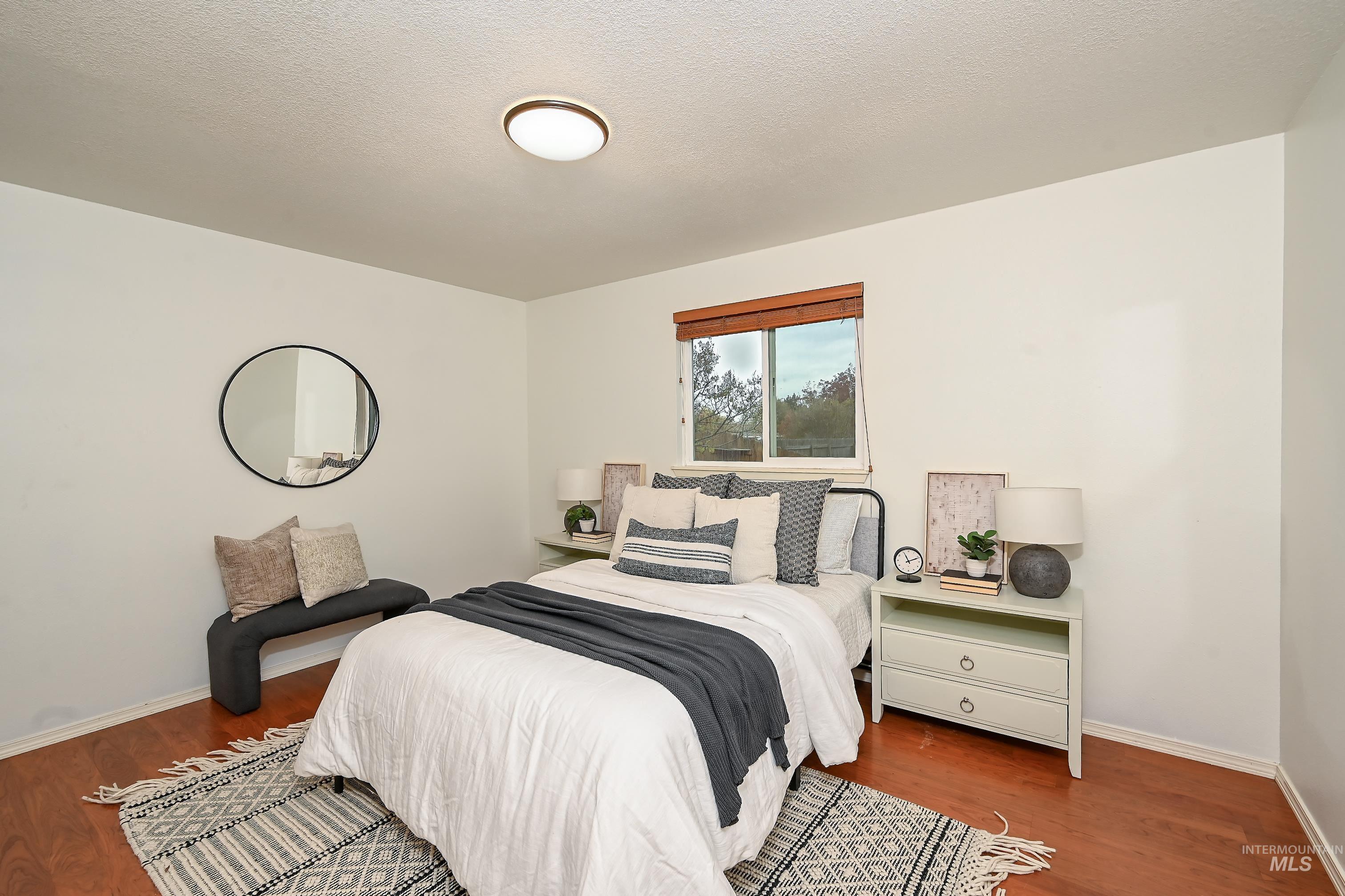 Bedroom with dark wood-type flooring and a textured ceiling