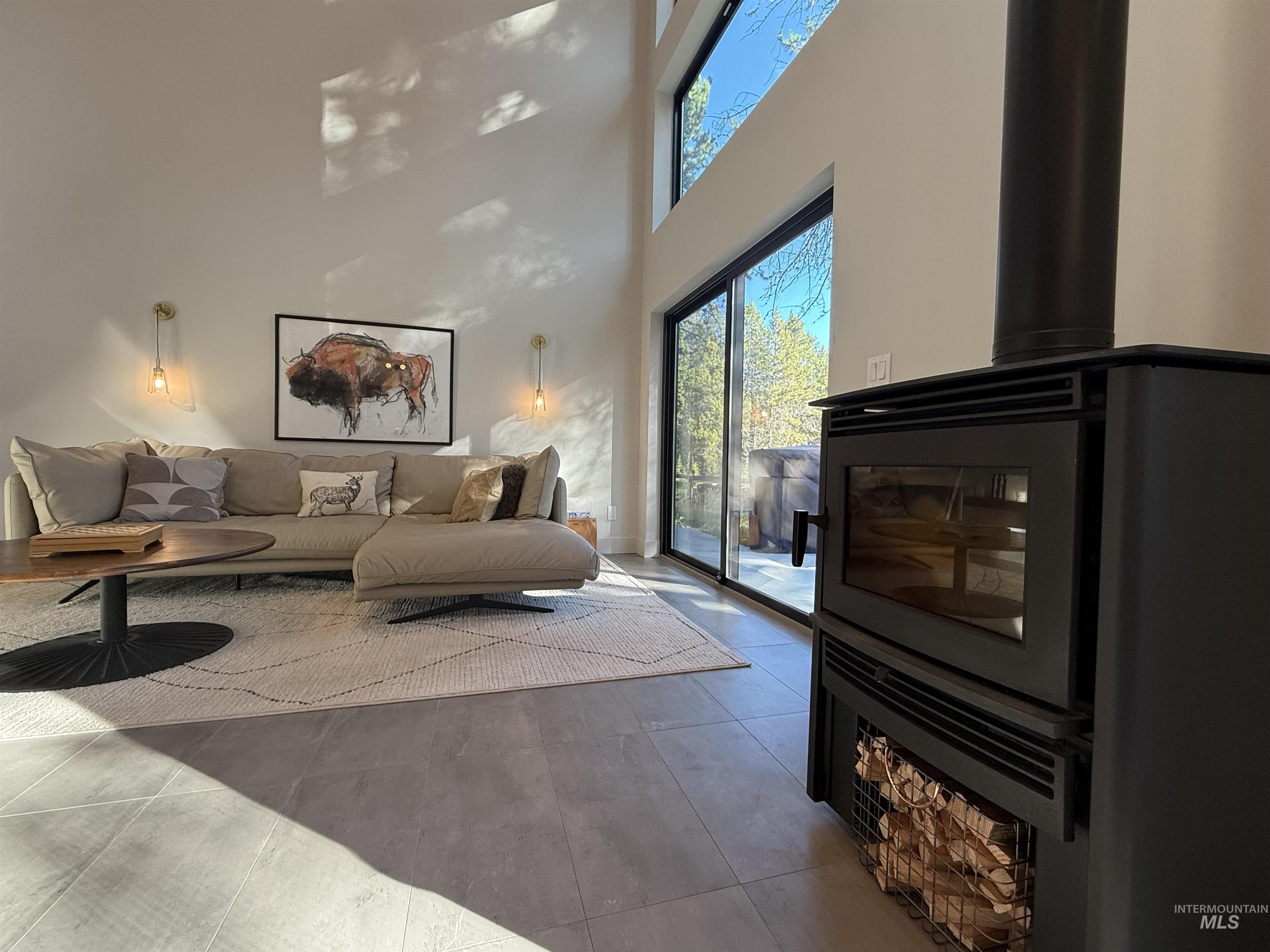 Living room featuring a high ceiling and a wood stove