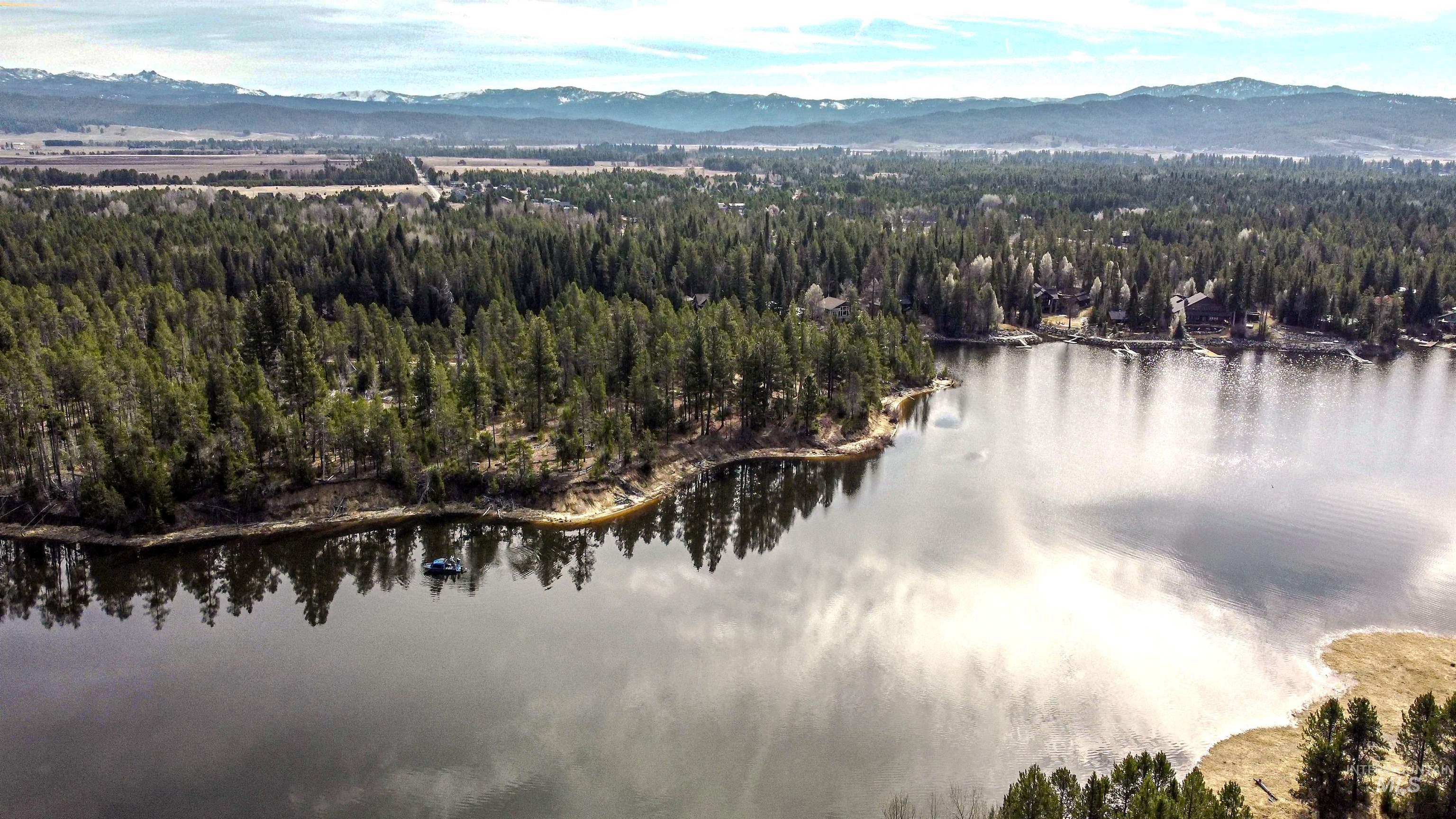 Drone / aerial view of a heavily wooded area and a water and mountain view