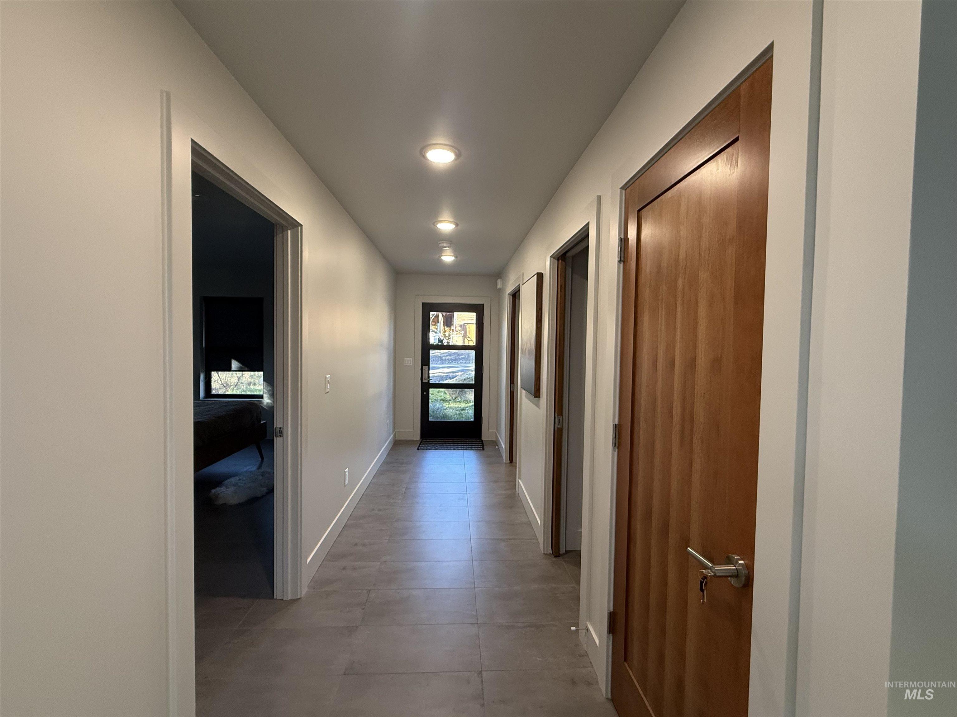 Corridor with baseboards and light tile patterned floors