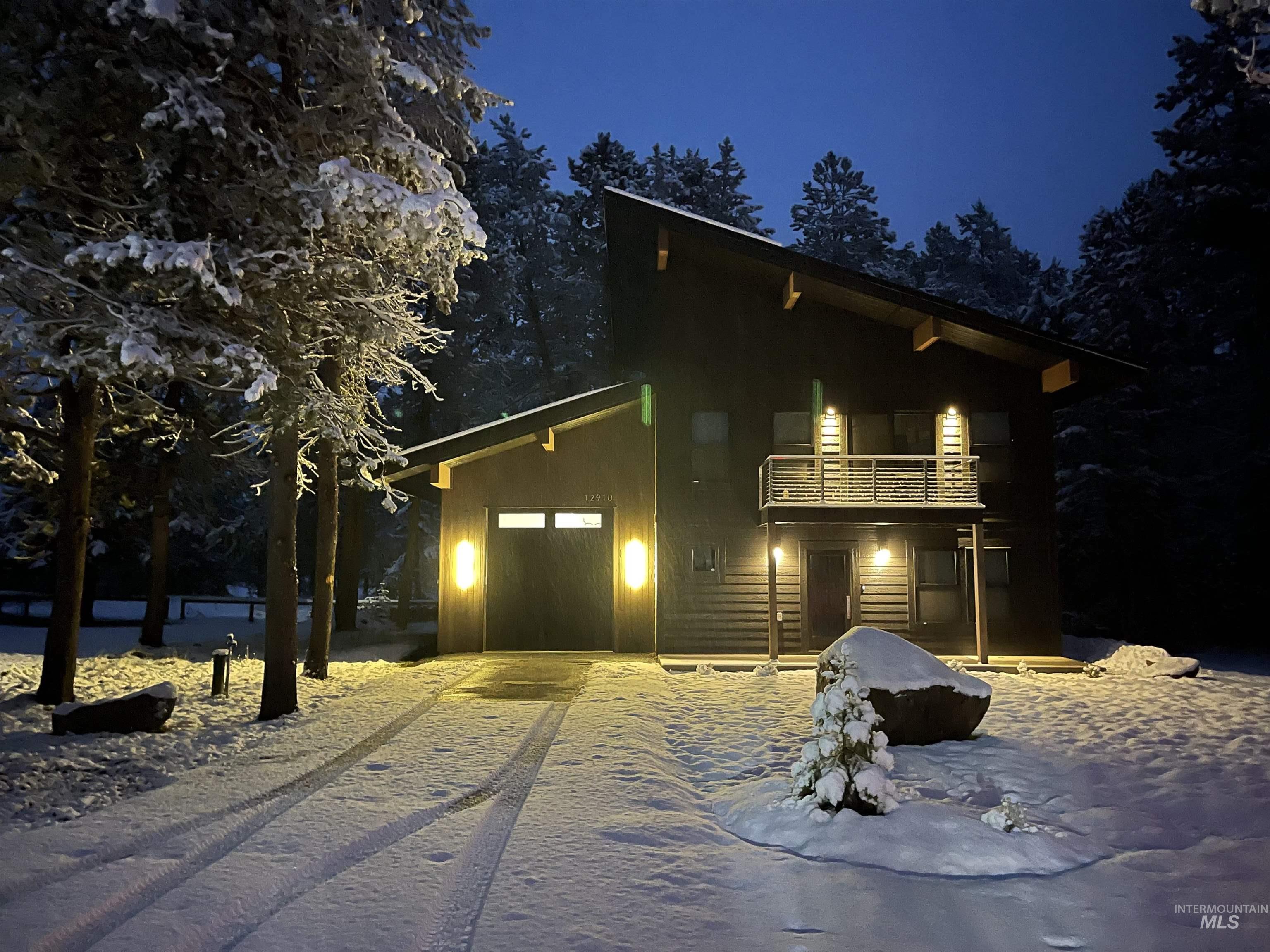 View of front of house with driveway, an attached garage, and a balcony