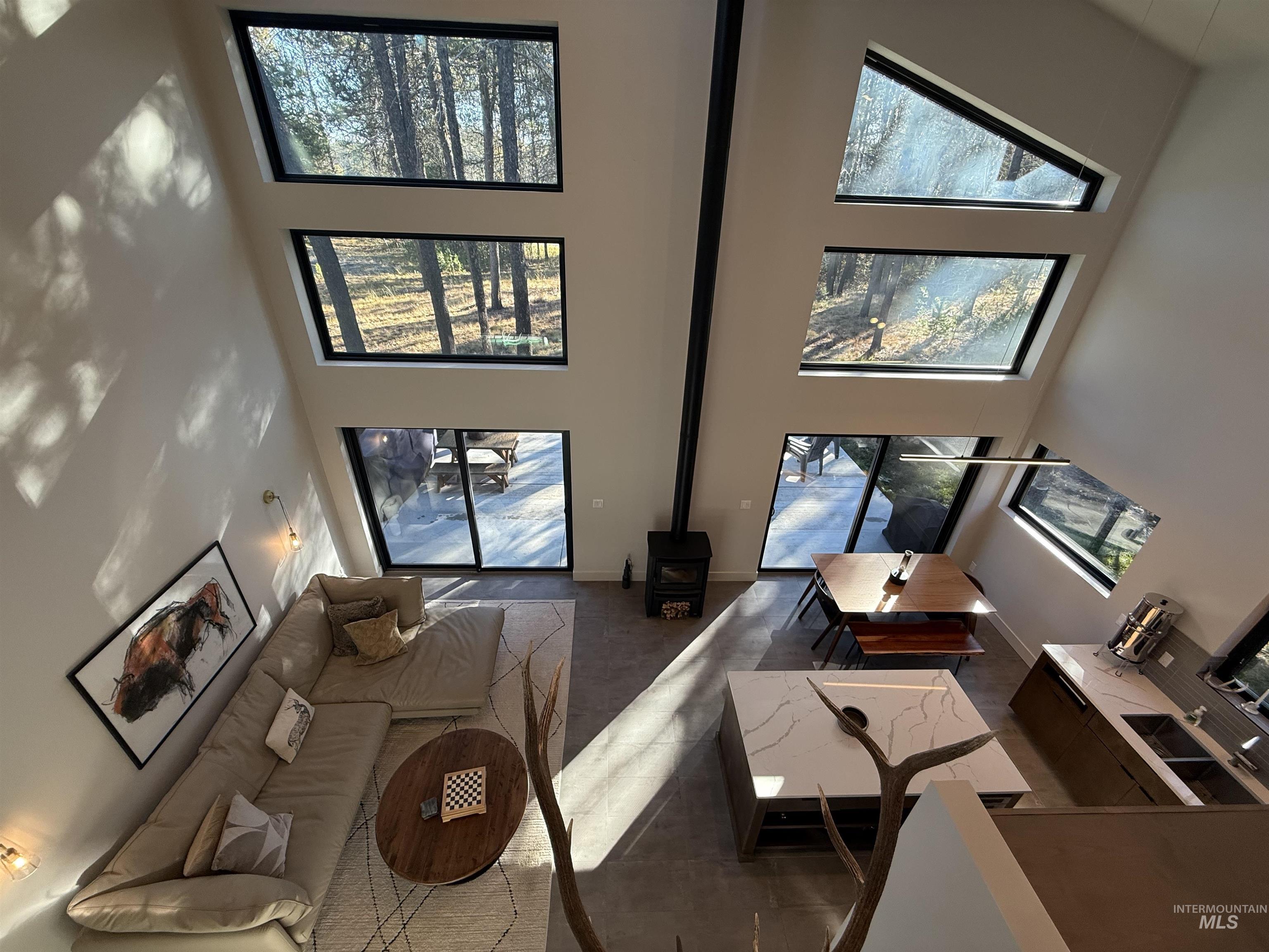 Living area with a wood stove and a high ceiling