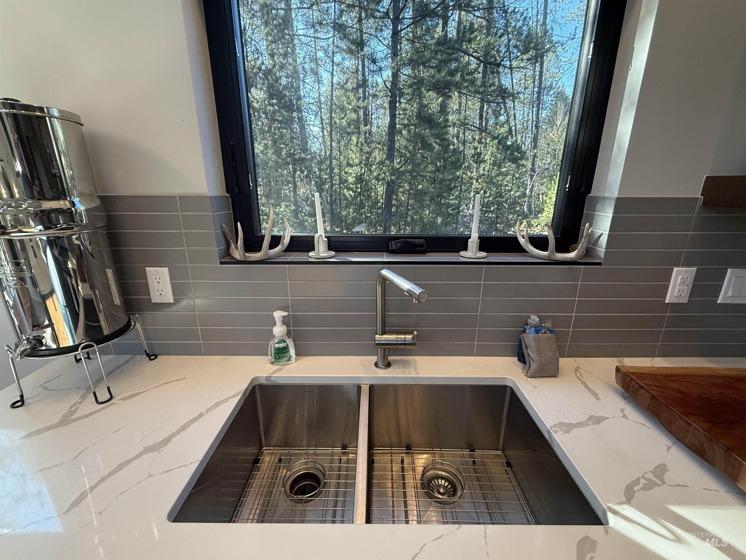 Kitchen view of light stone counters and a sink