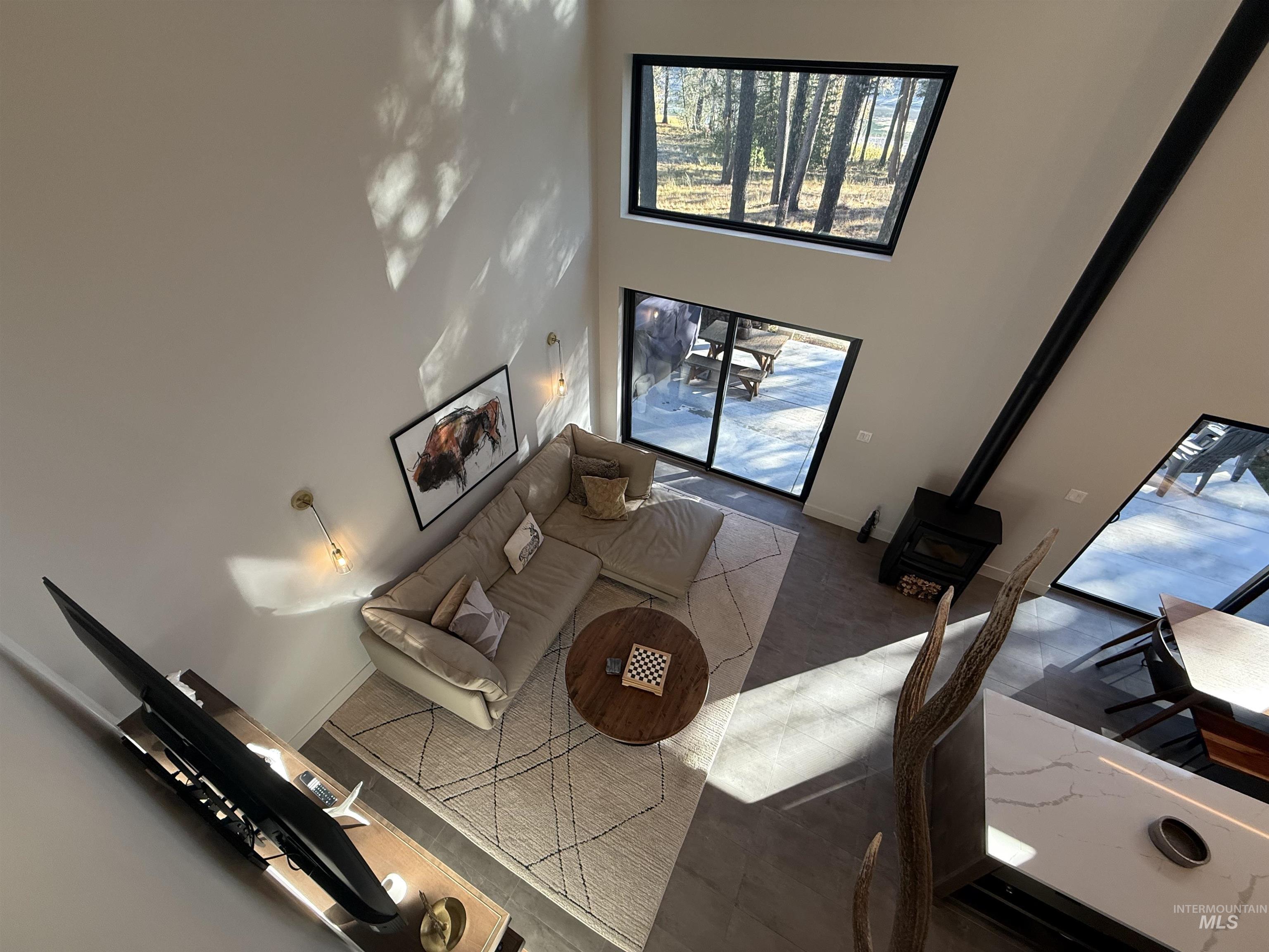 Living room with a wood stove and a high ceiling