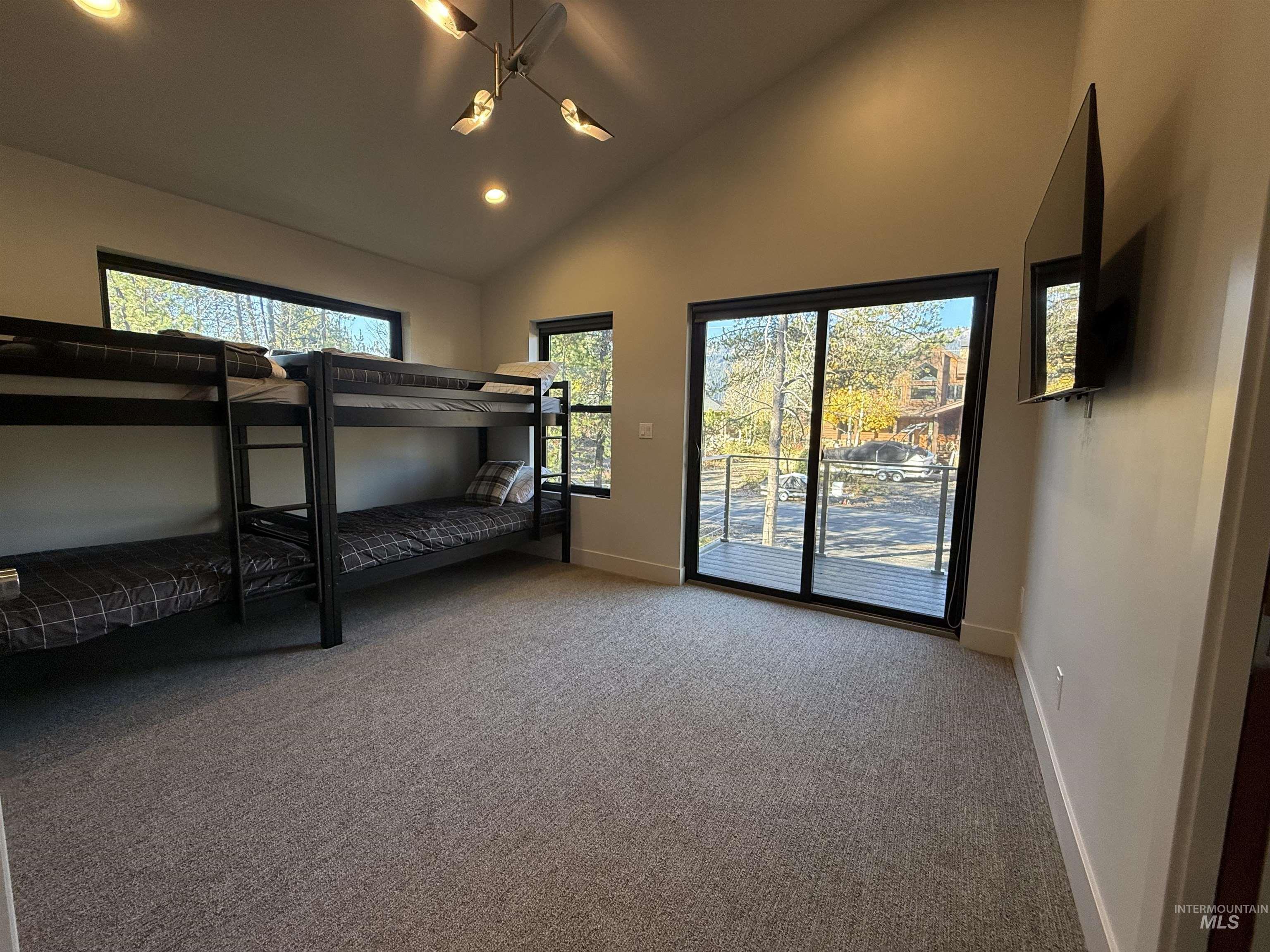 Carpeted bedroom with lofted ceiling, multiple windows, access to outside, and recessed lighting
