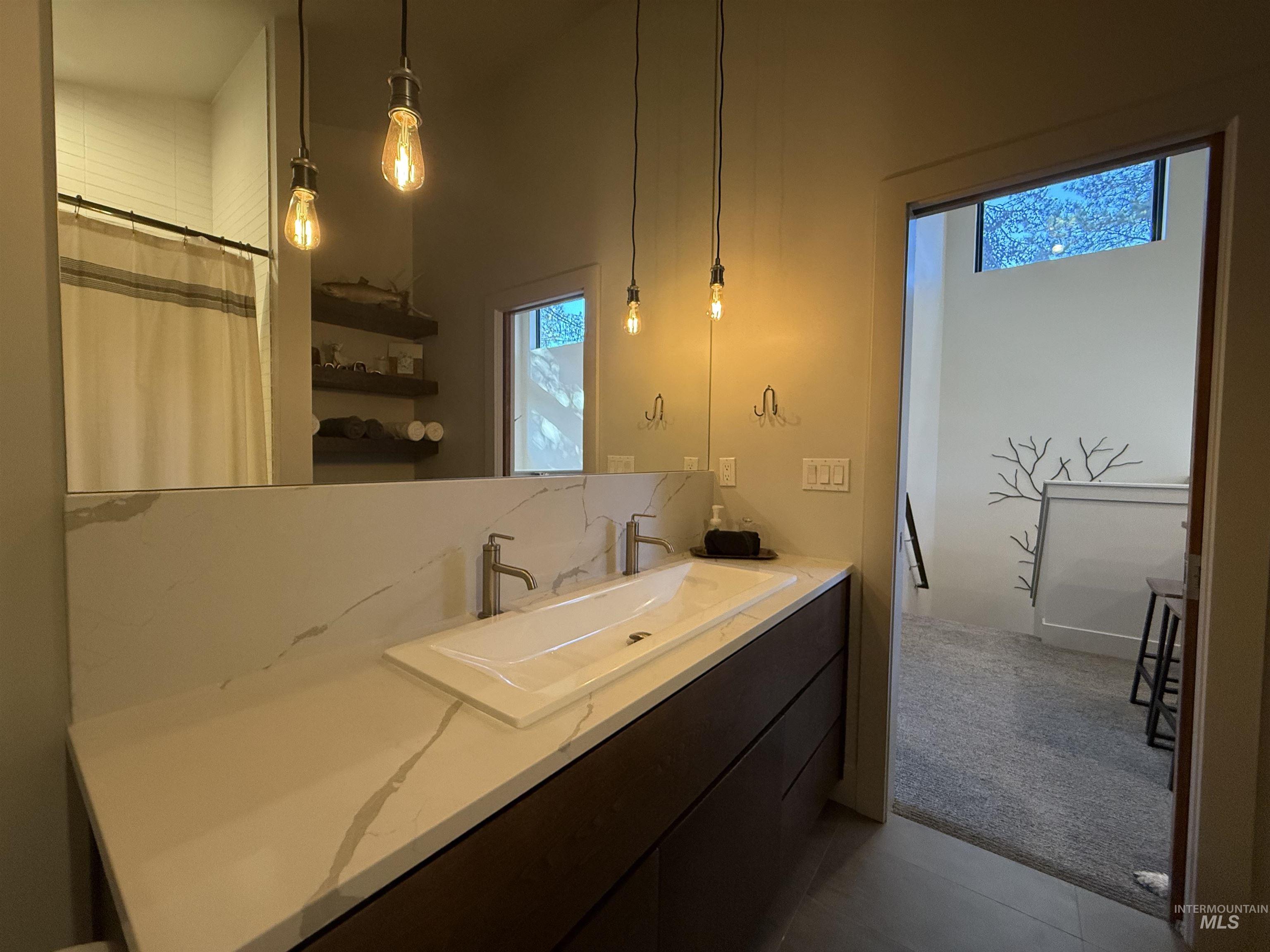 Bathroom featuring vanity, a shower with shower curtain, light colored carpet, and tasteful backsplash