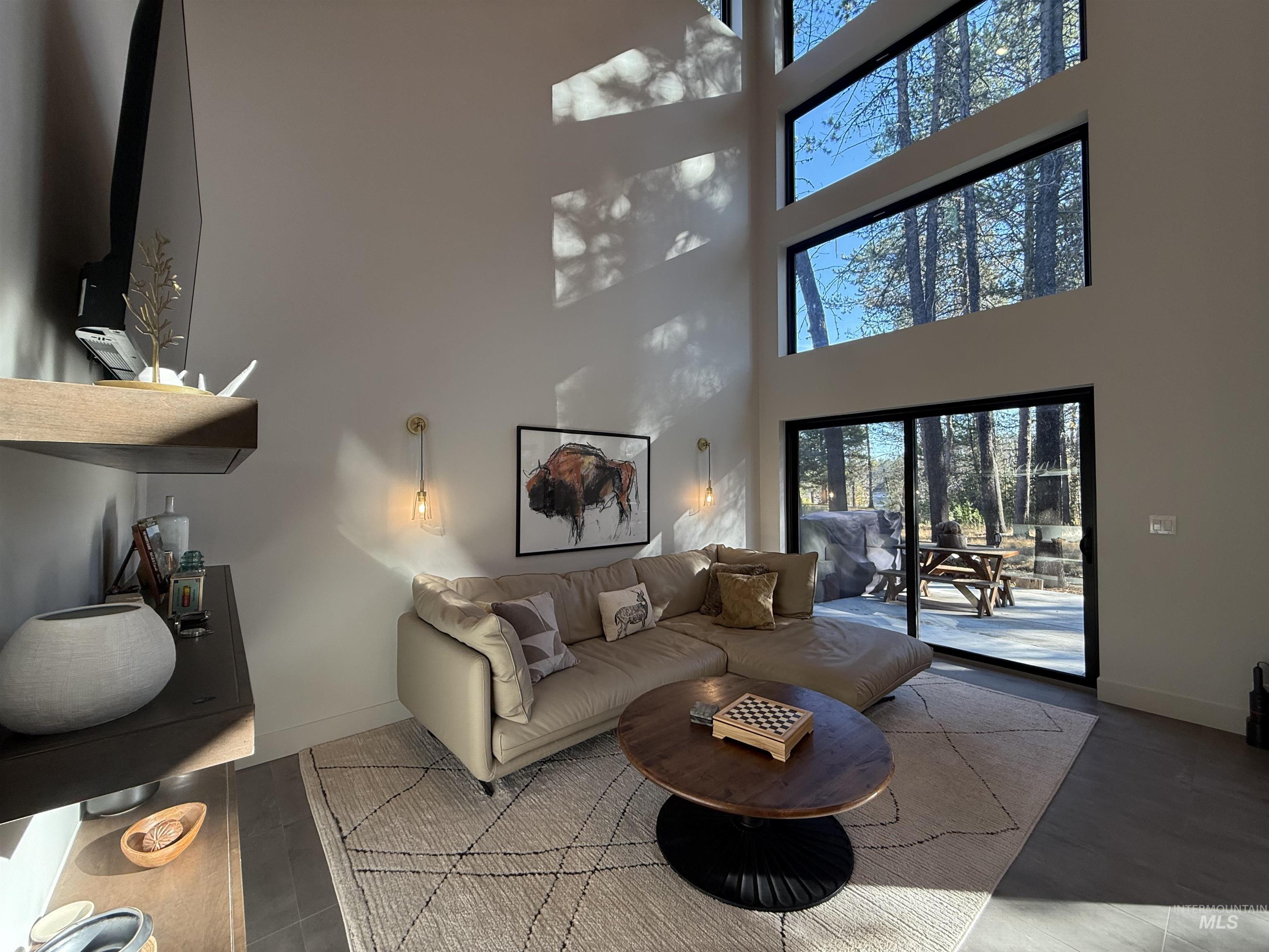 Living room featuring baseboards and a high ceiling