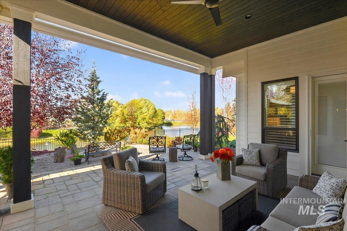 View of patio / terrace with an outdoor living space, a ceiling fan, and a water view