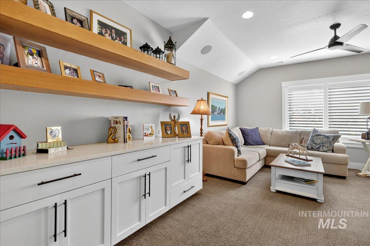 Living room with dark carpet, lofted ceiling, ceiling fan, and recessed lighting