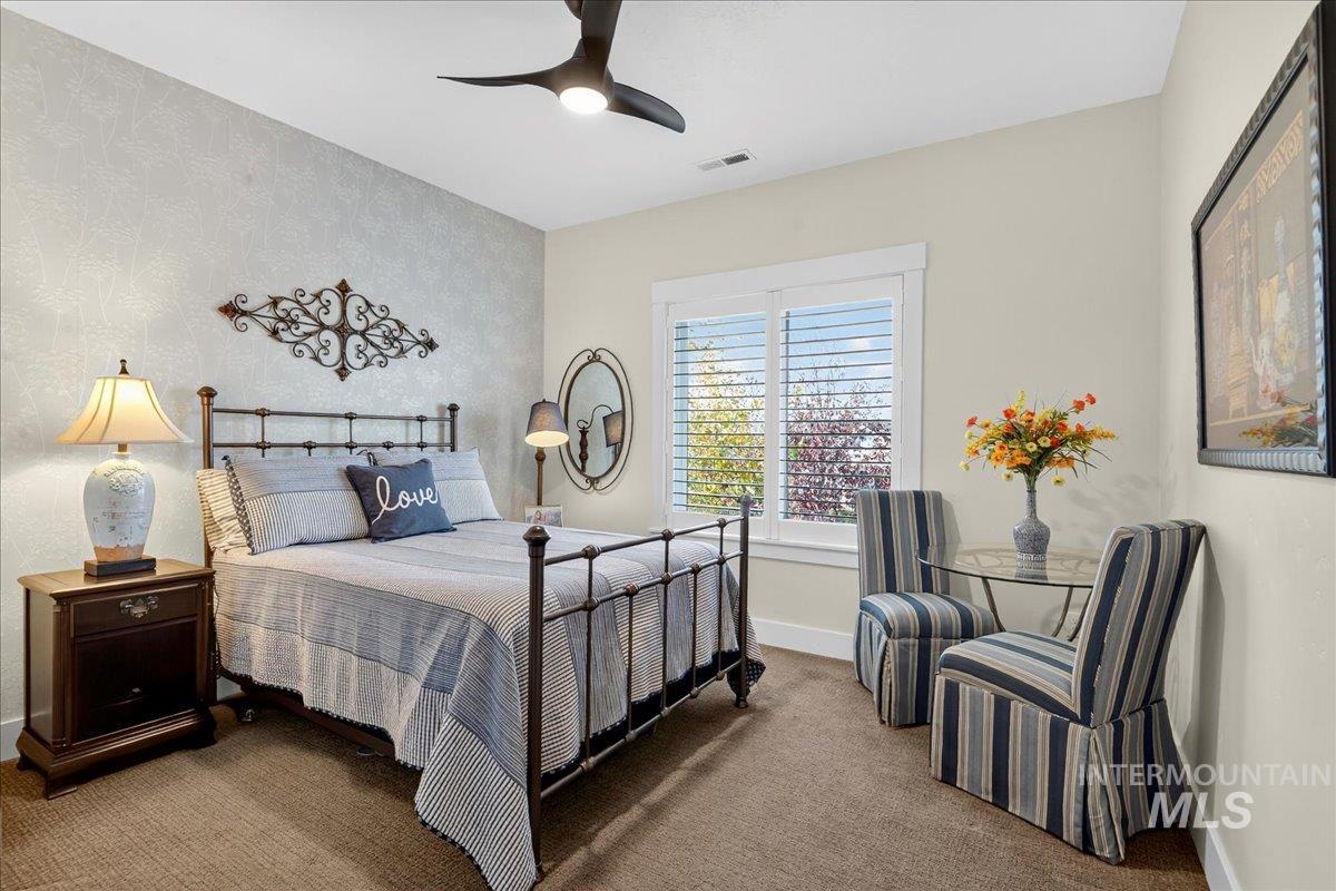 Carpeted bedroom featuring baseboards and ceiling fan