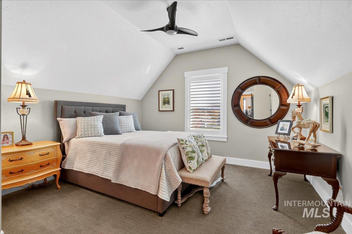 Bedroom featuring carpet floors, lofted ceiling, ceiling fan, and a textured ceiling
