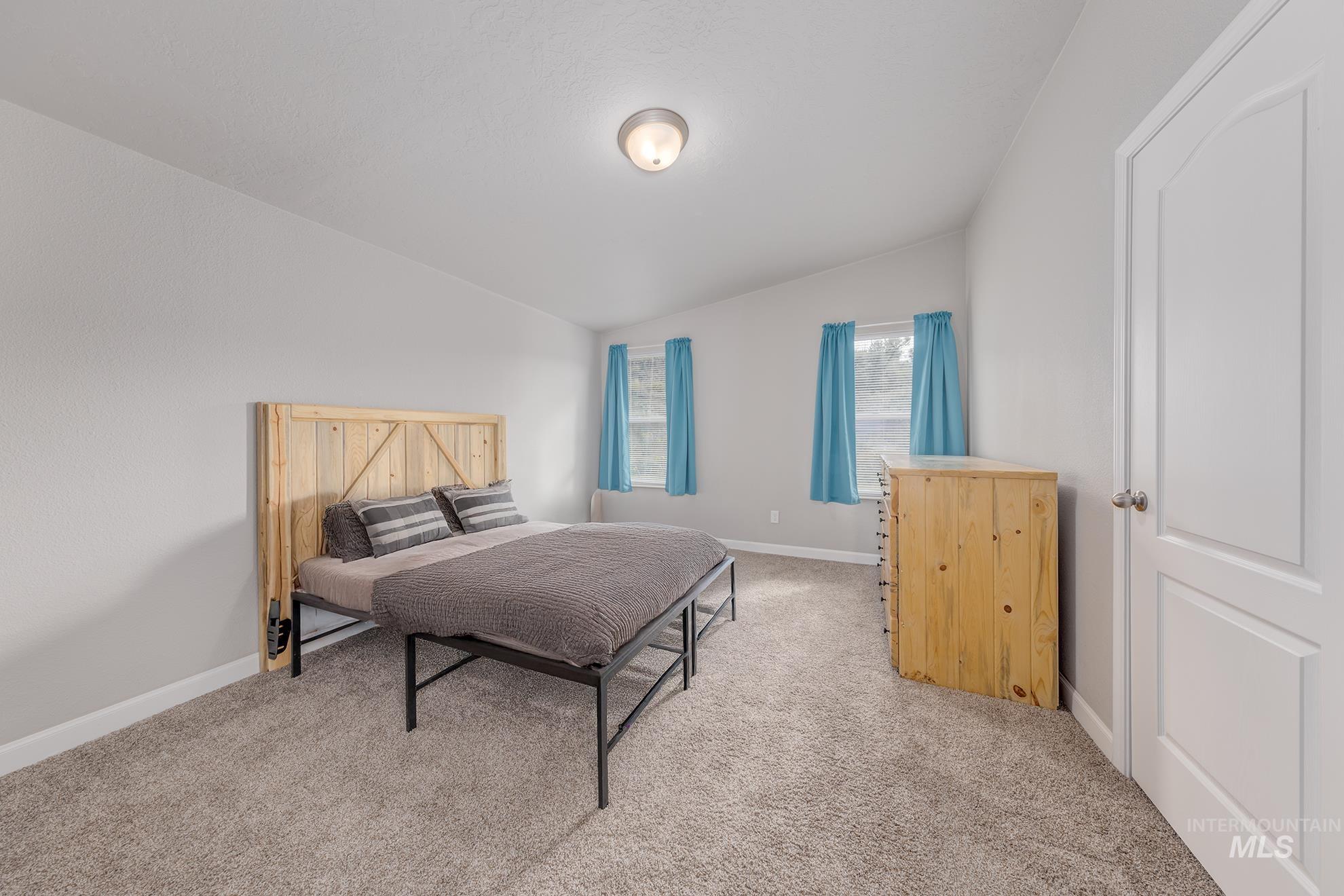 Bedroom featuring light colored carpet and lofted ceiling
