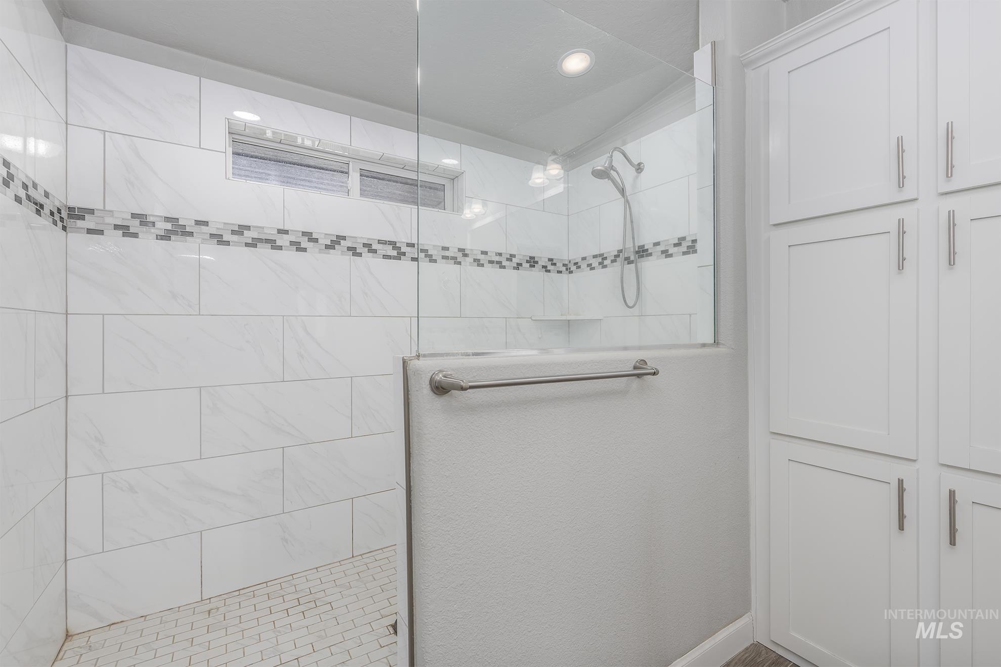 Bathroom featuring a walk in shower, a closet, and recessed lighting