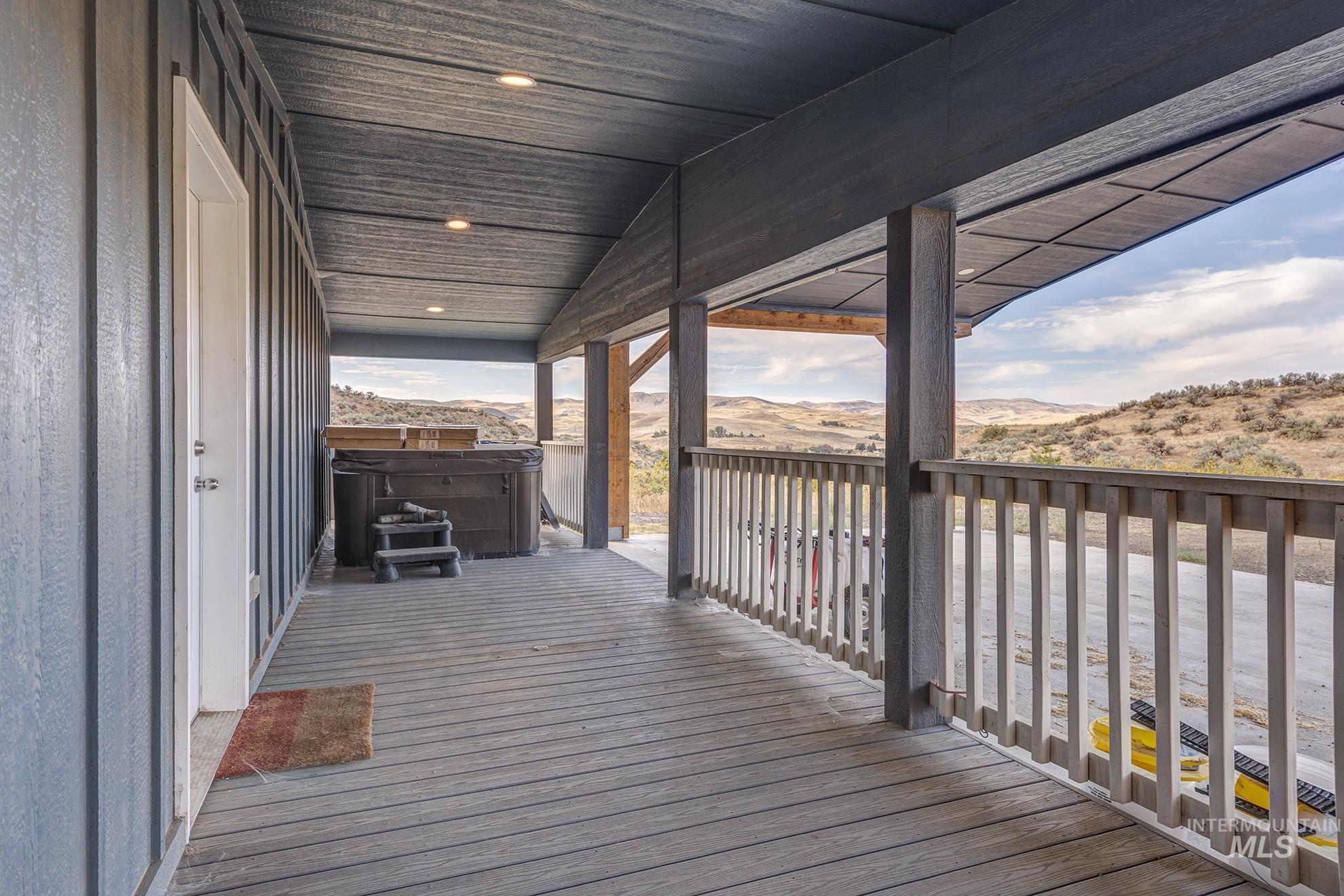 Wooden deck featuring a hot tub and a mountain view
