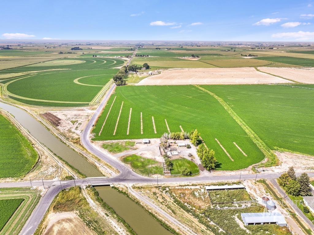 Aerial view of property and surrounding area featuring rural landscape and extensive farmland