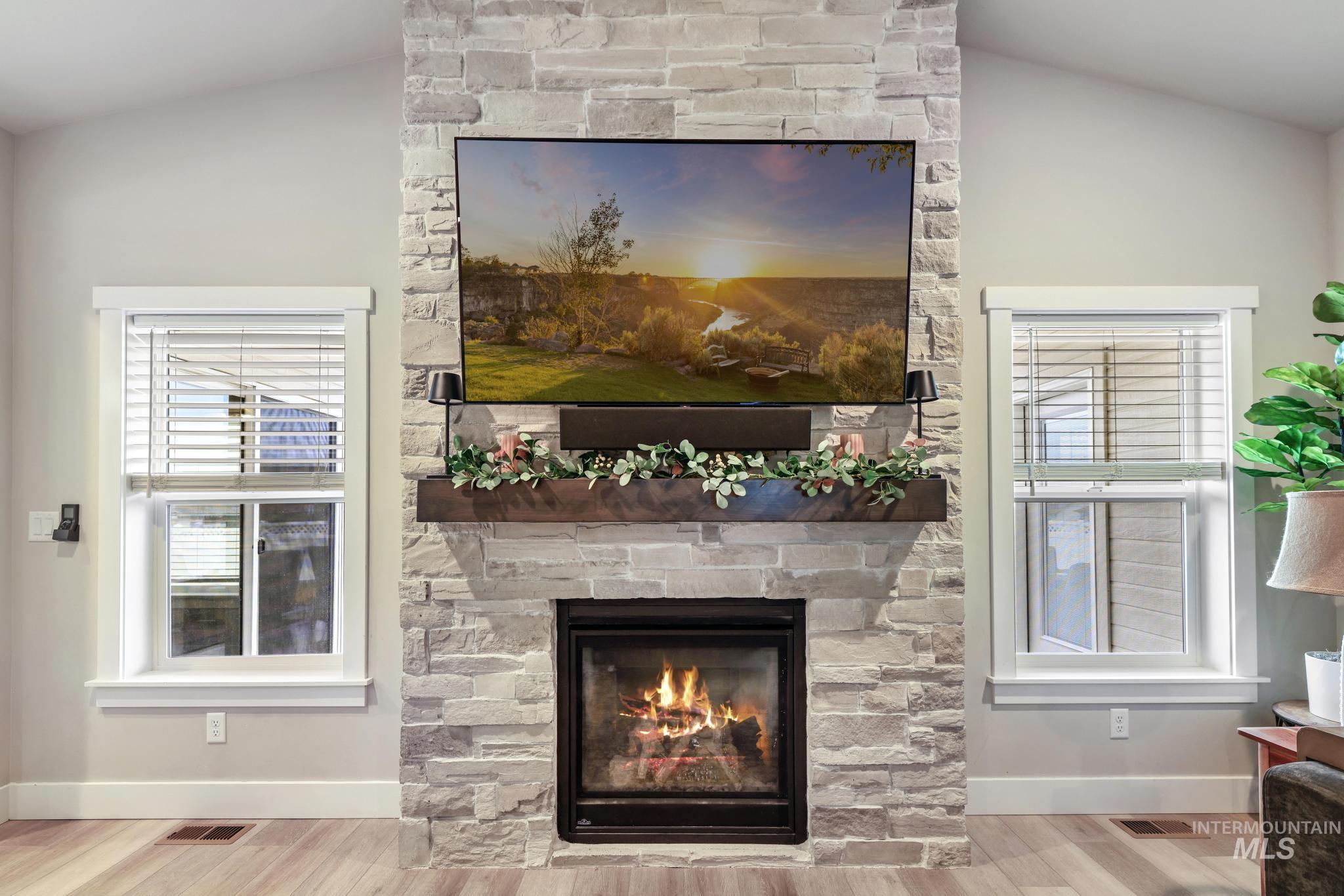 Detailed view of a stone fireplace and wood finished floors