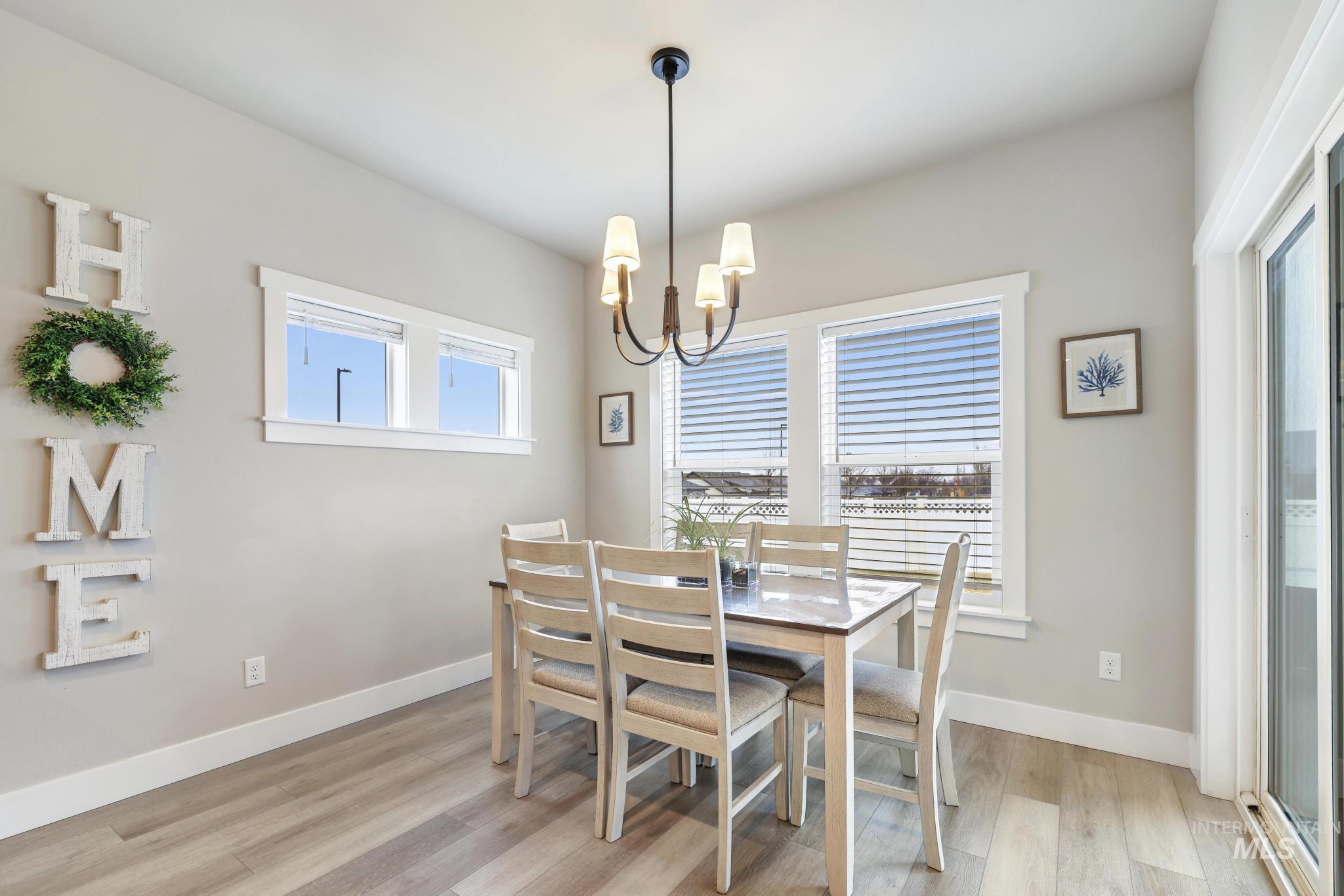 Dining area with light wood-style flooring and hanging lights
