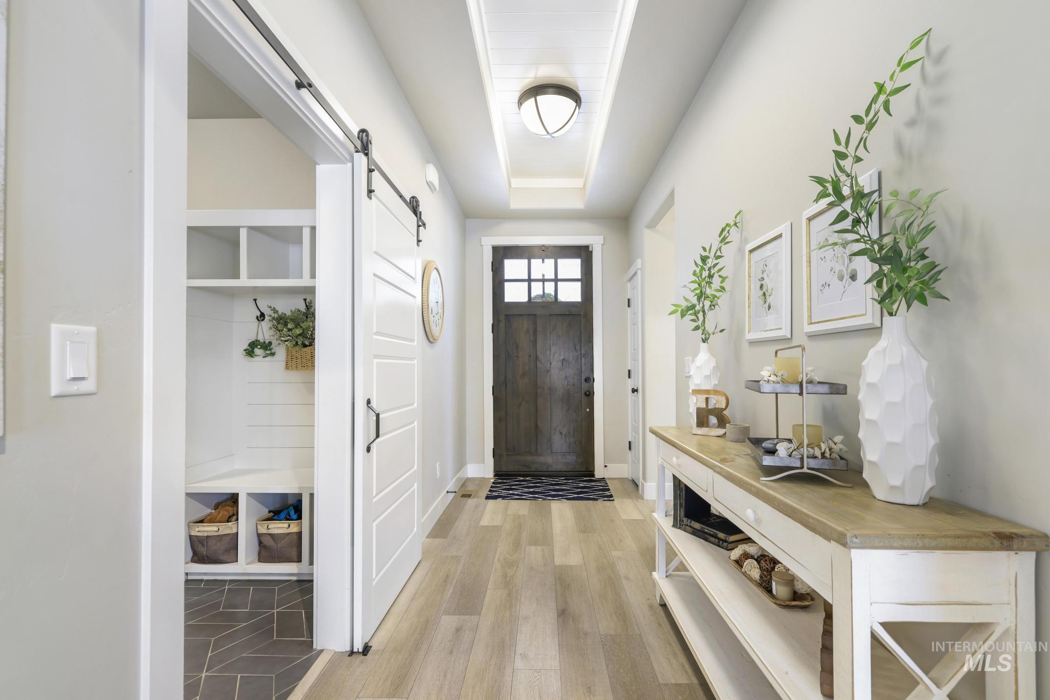 Entryway with a barn door and light wood-type flooring