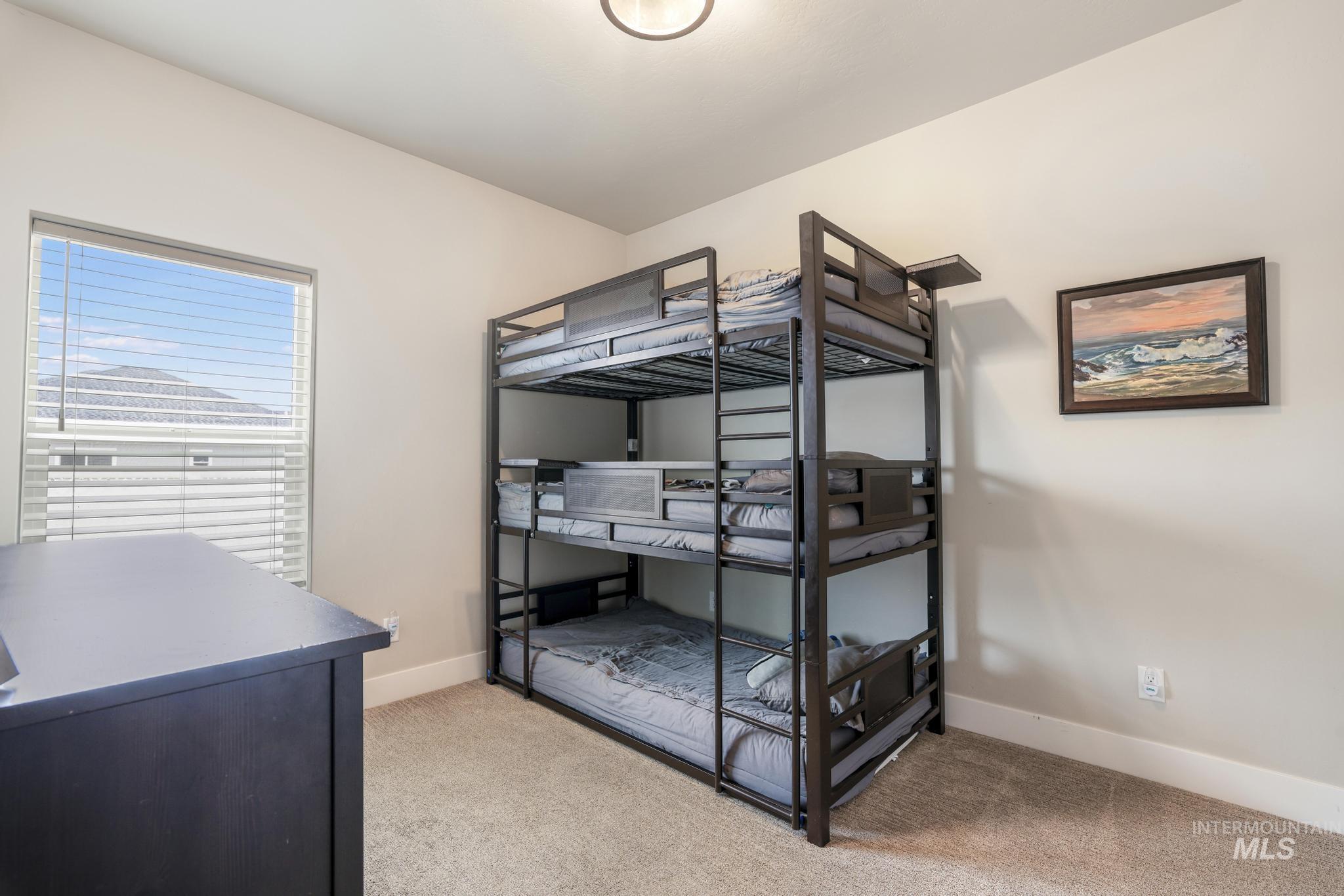 Bedroom featuring light colored carpet and baseboards