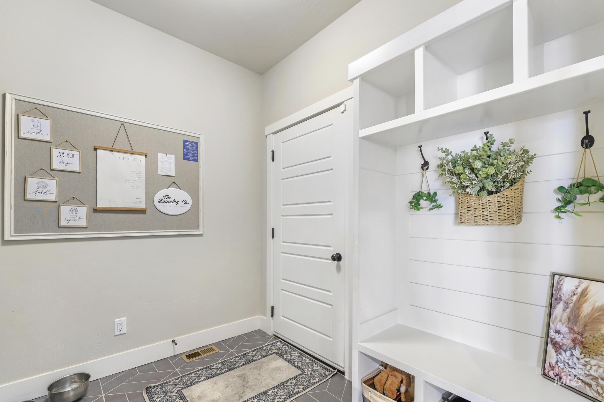 Mudroom with baseboards and dark tile patterned floors
