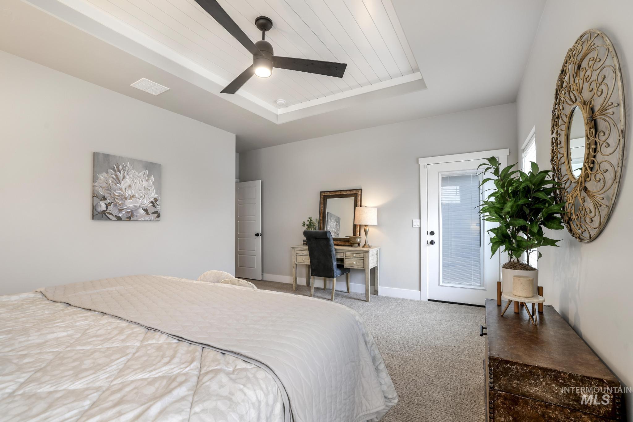 Carpeted bedroom with a wooden tray ceiling, access to outside, and a ceiling fan