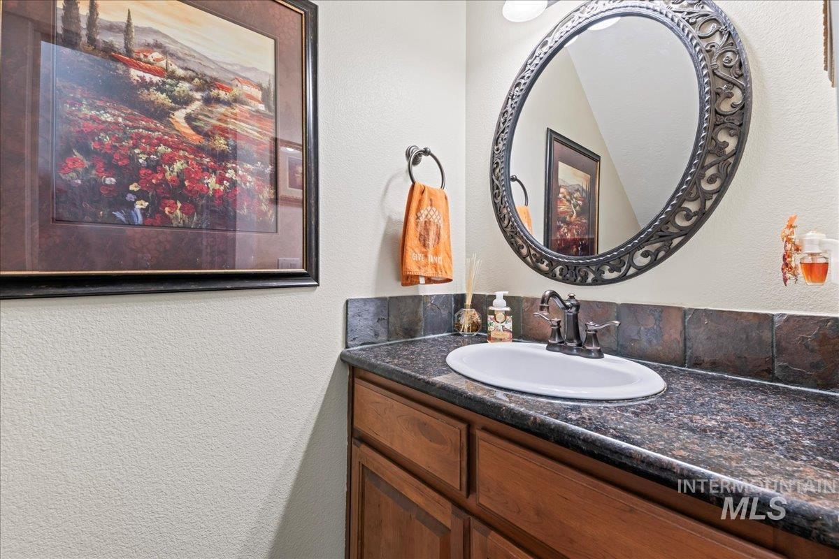 Bathroom featuring a textured wall and vanity