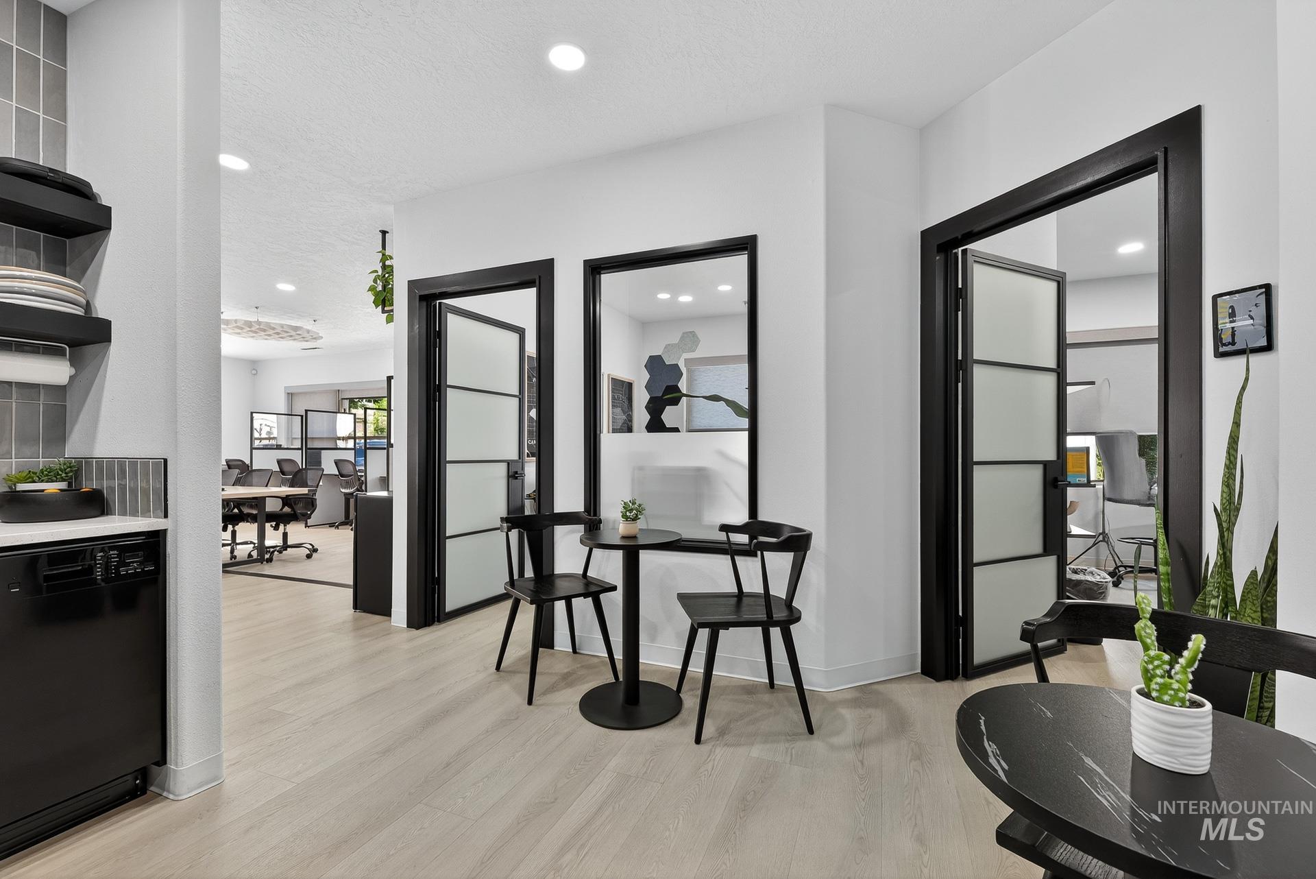Corridor with light wood finished floors, recessed lighting, and a textured ceiling