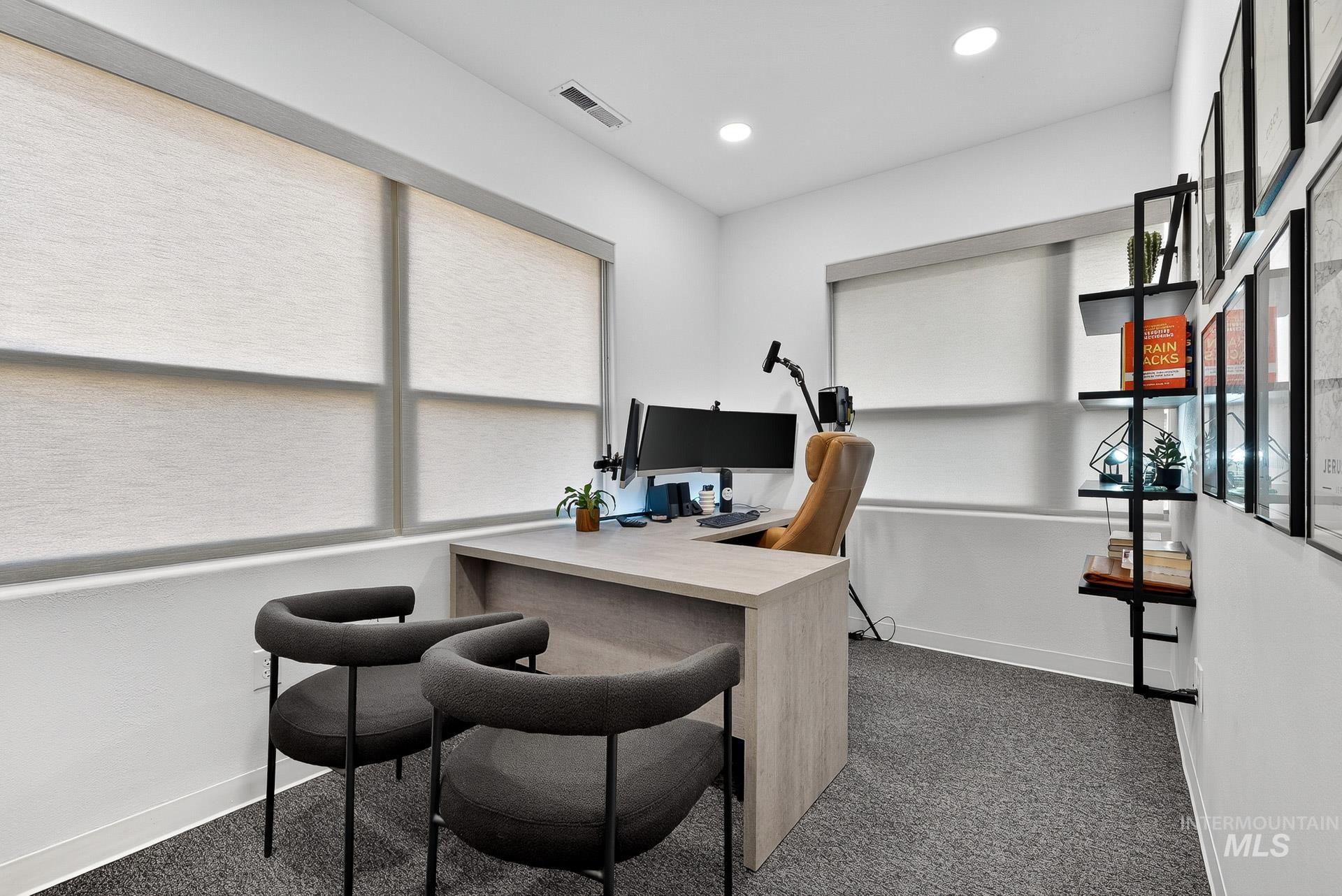 Office space featuring dark carpet and recessed lighting