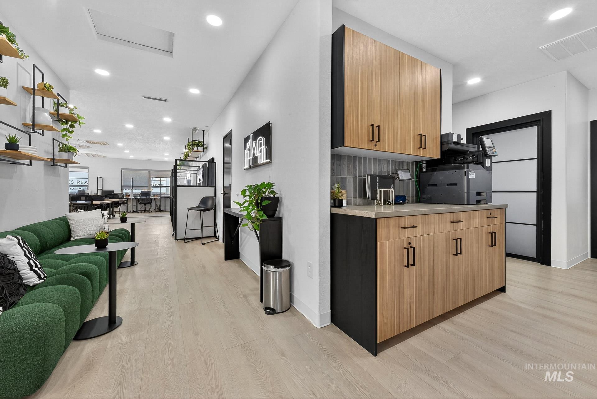 Kitchen with light wood-type flooring, recessed lighting, modern cabinets, open floor plan, and backsplash