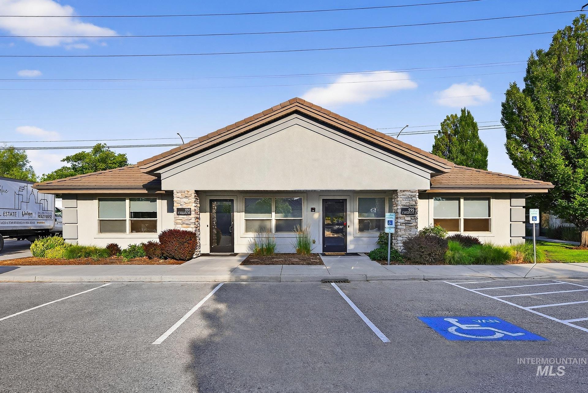 View of building exterior featuring uncovered parking