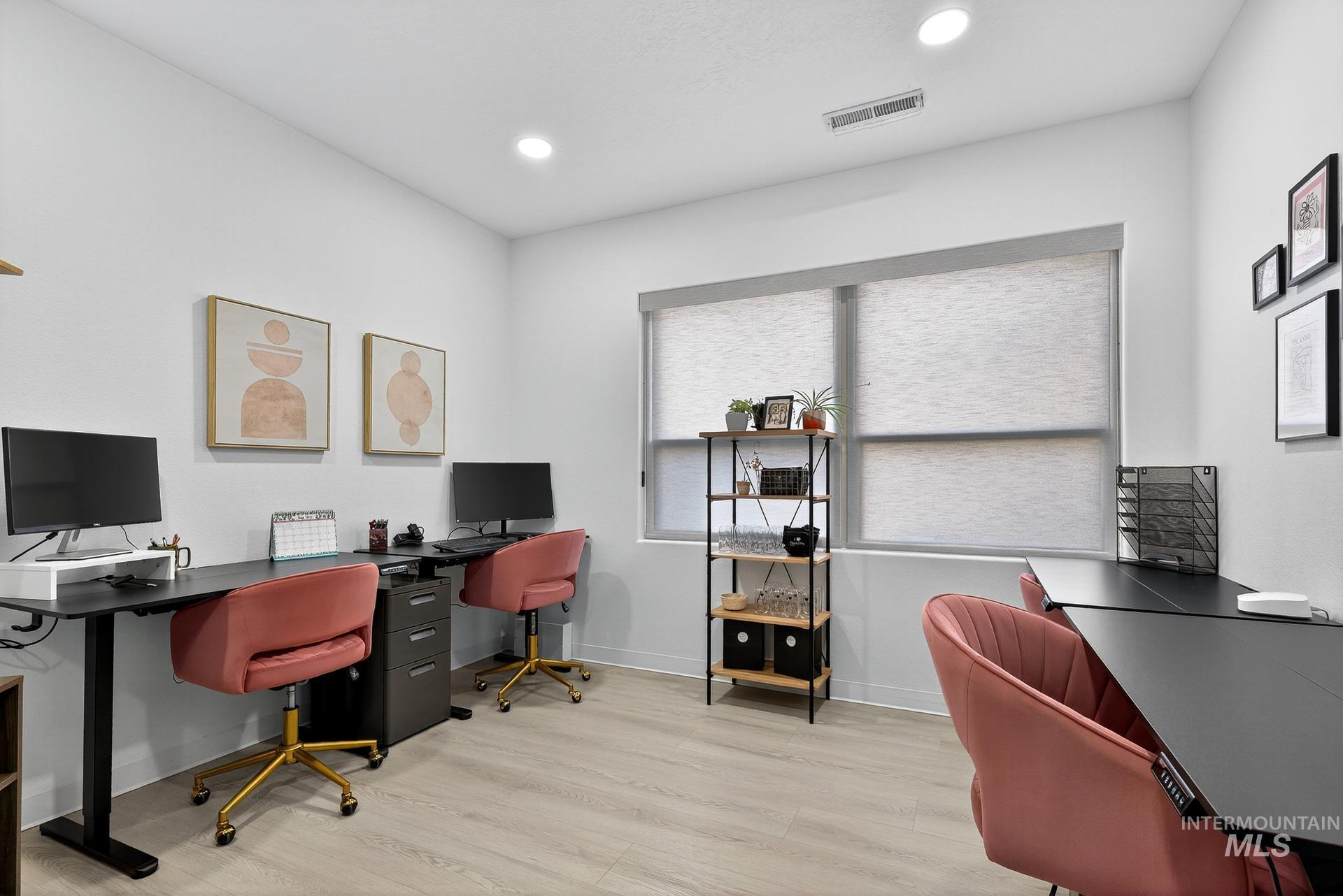 Office space featuring light wood finished floors and recessed lighting