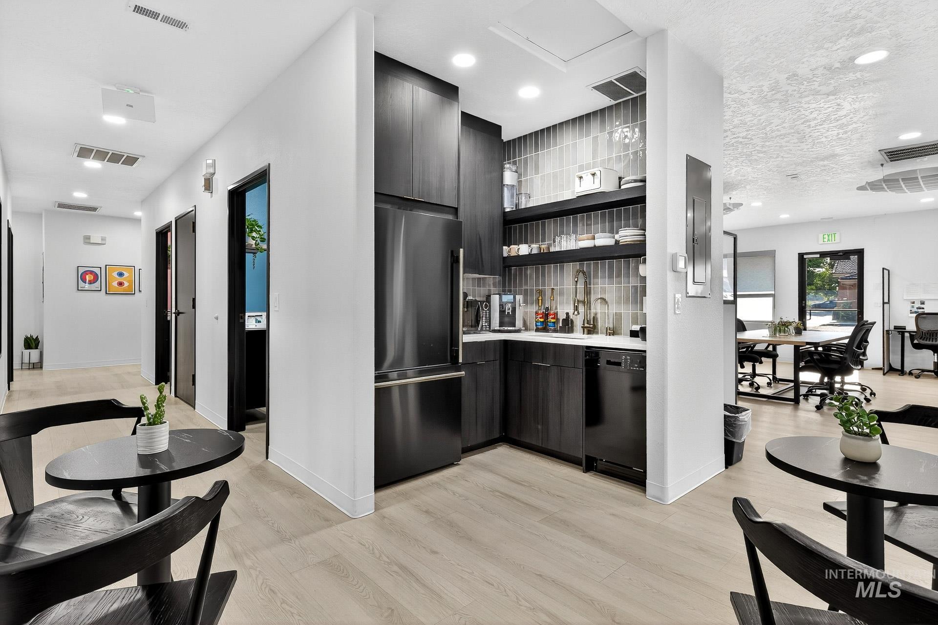 Kitchen with modern cabinets, open shelves, recessed lighting, high end refrigerator, and light wood-style floors