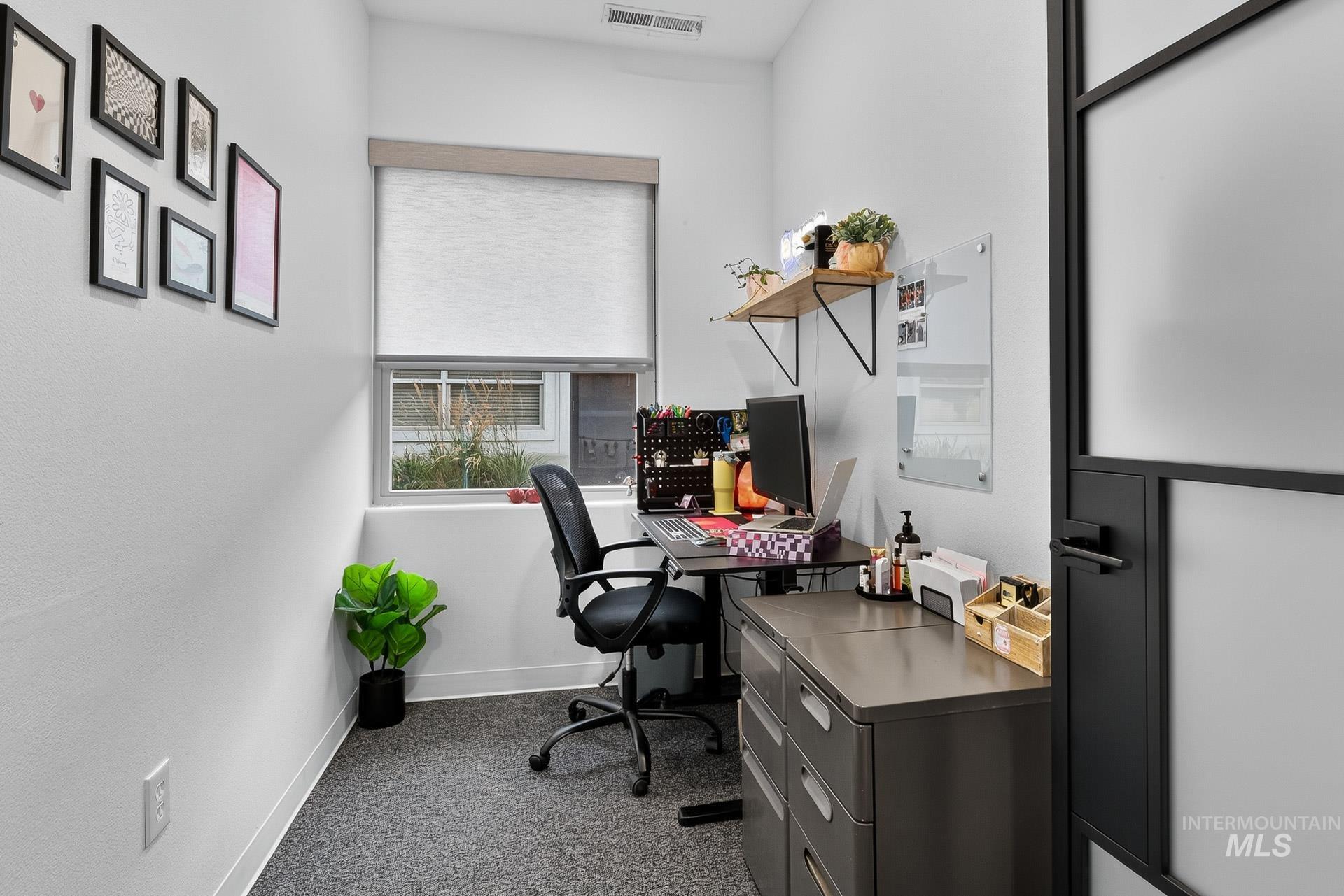 Office featuring baseboards and dark carpet