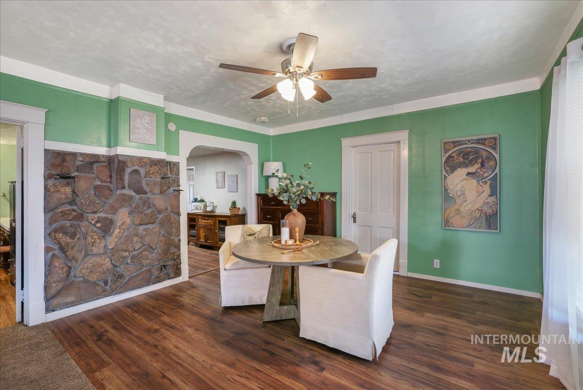 Dining area featuring arched walkways, ceiling fan, and wood finished floors