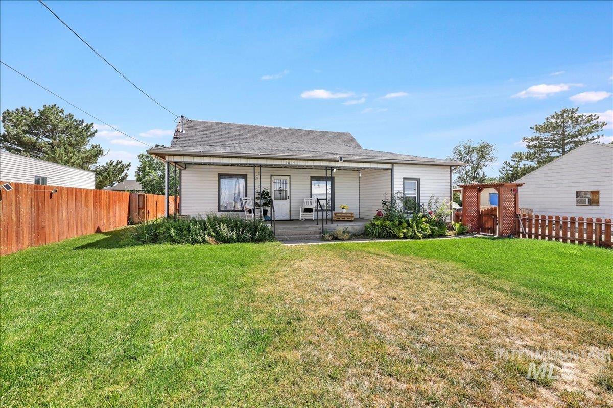 Back of house with covered porch and a fenced backyard