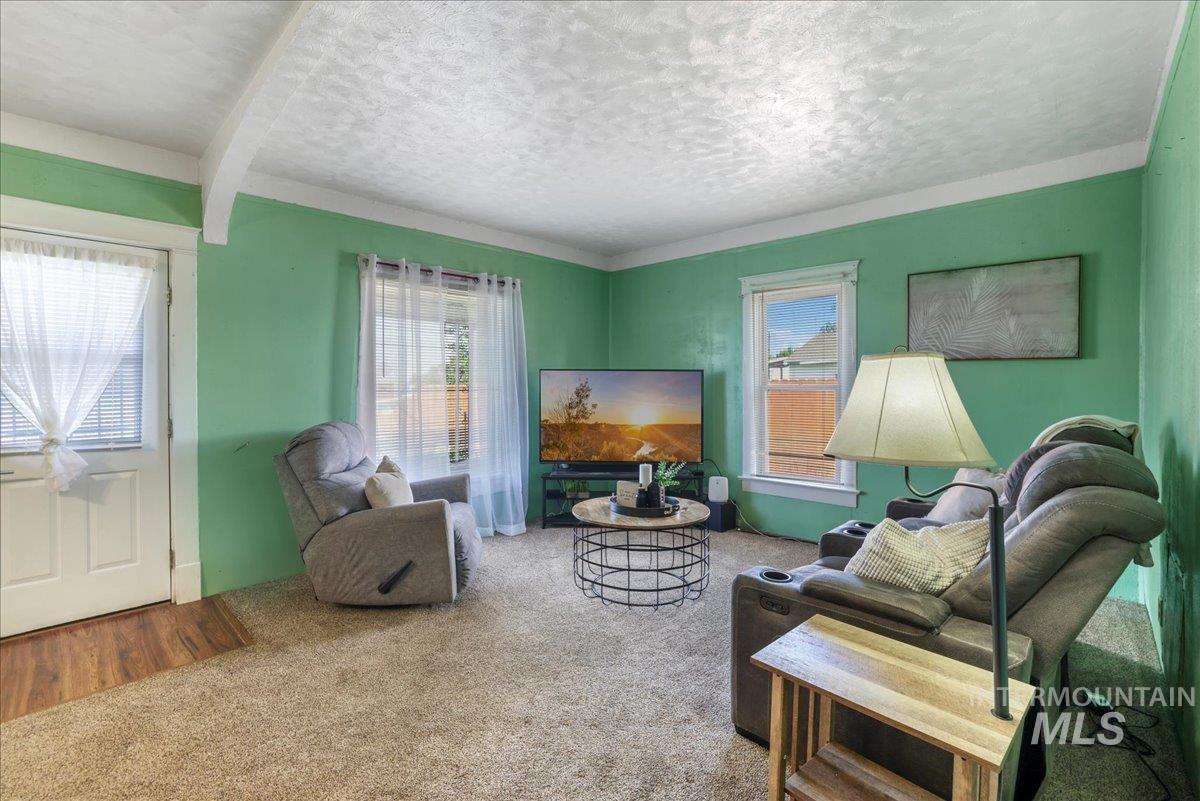 Carpeted living area featuring a textured ceiling