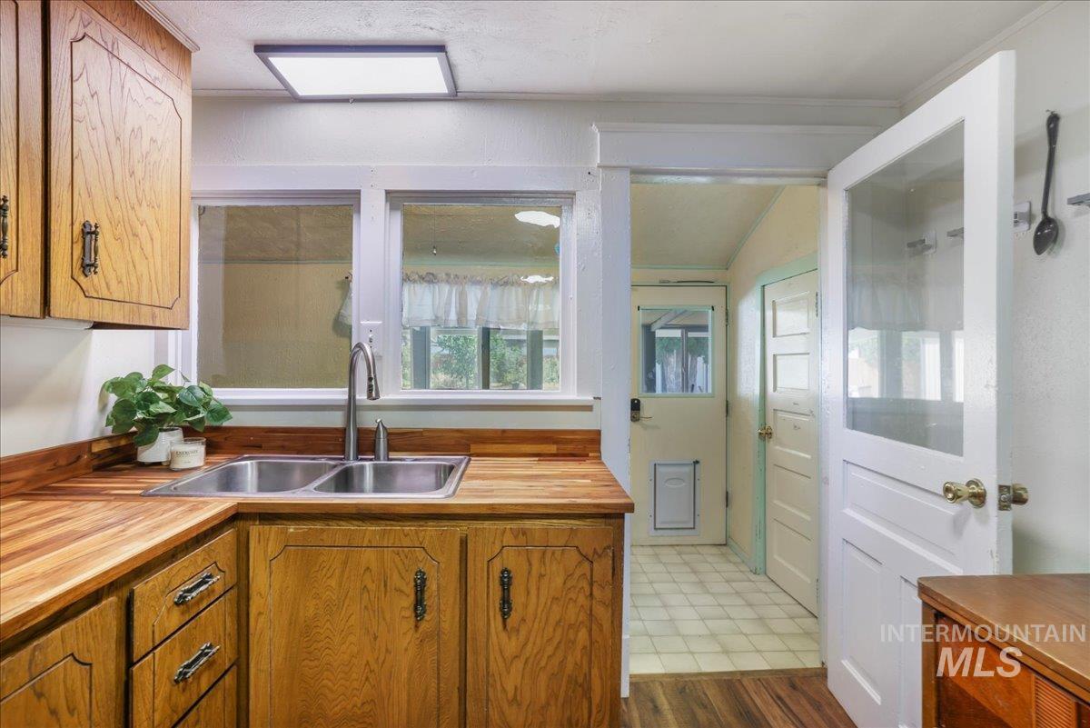 Kitchen with butcher block countertops, dark flooring, and brown cabinets