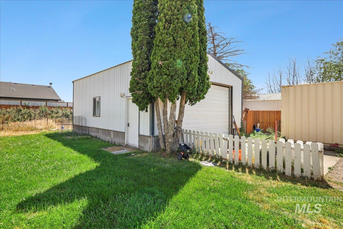 Rear view of house featuring an outdoor structure and a detached garage