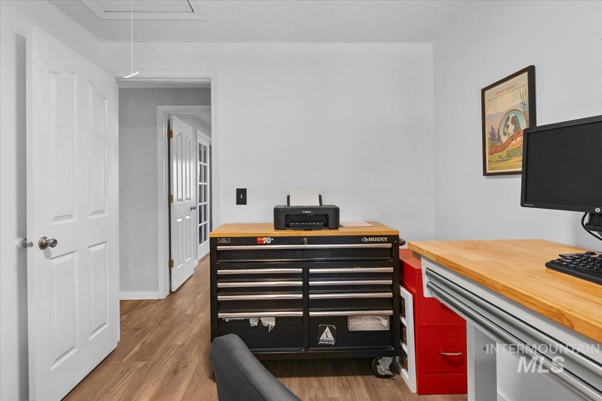 Home office with attic access, dark wood finished floors, and a textured ceiling