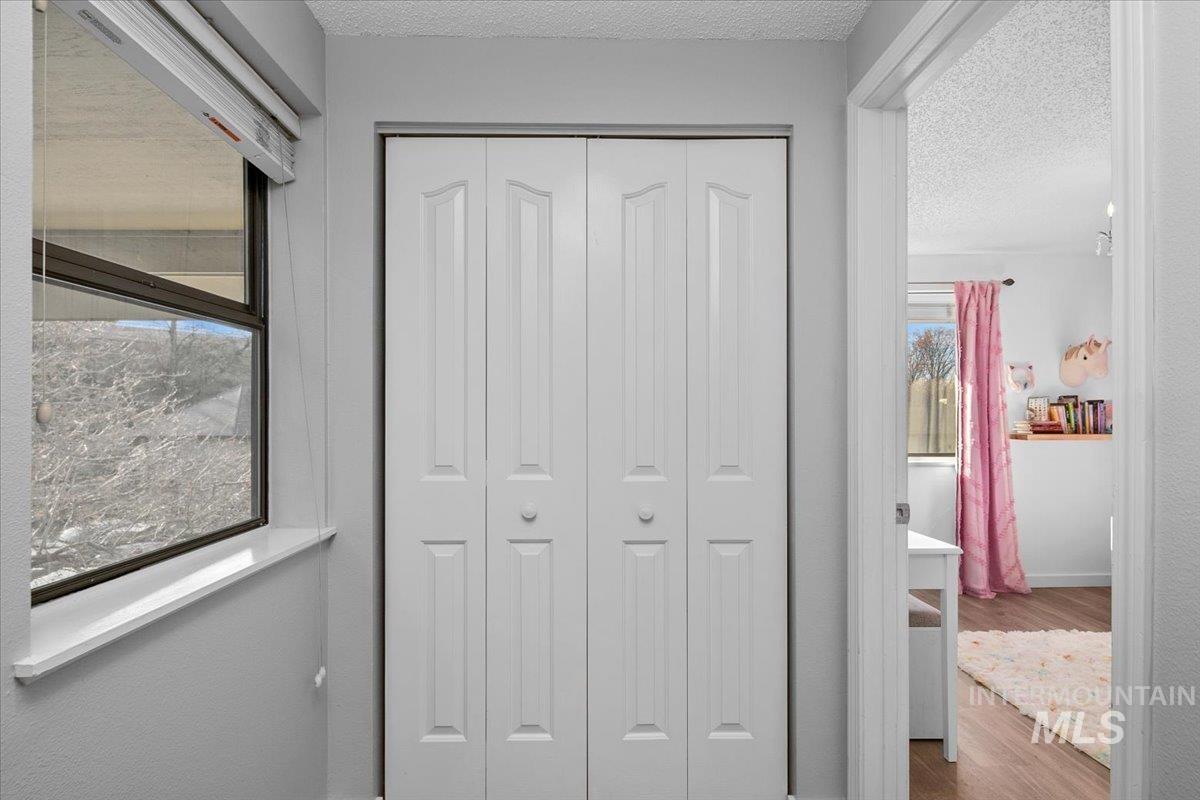 Hall featuring wood finished floors and a textured ceiling