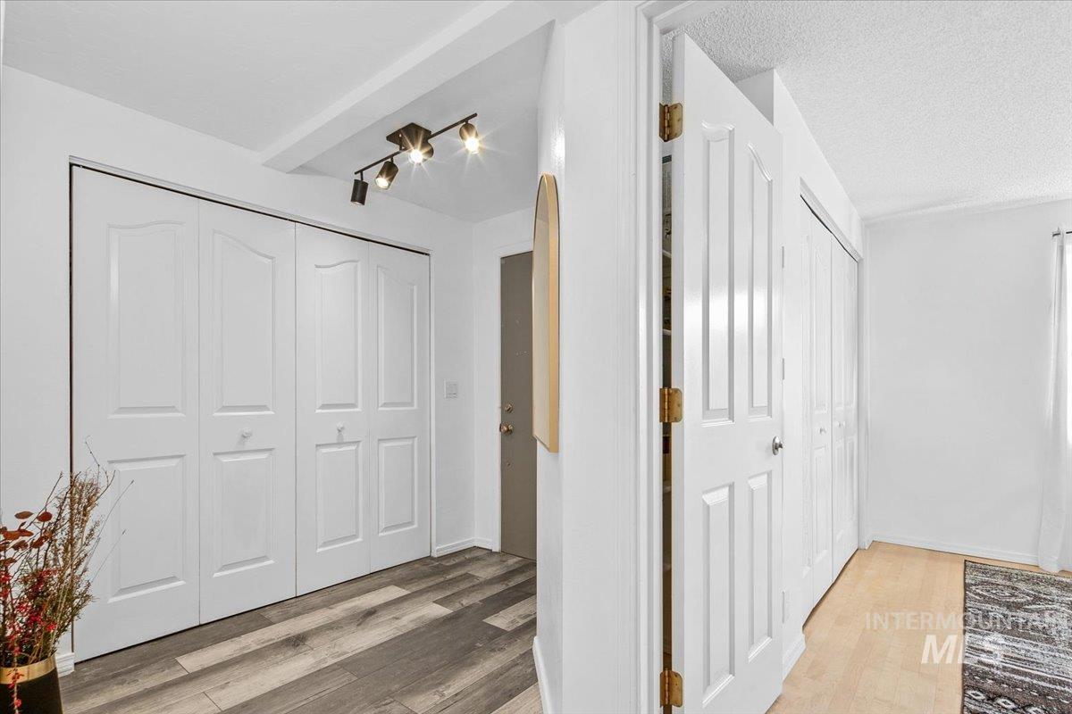 Hall featuring light wood-style floors and a textured ceiling