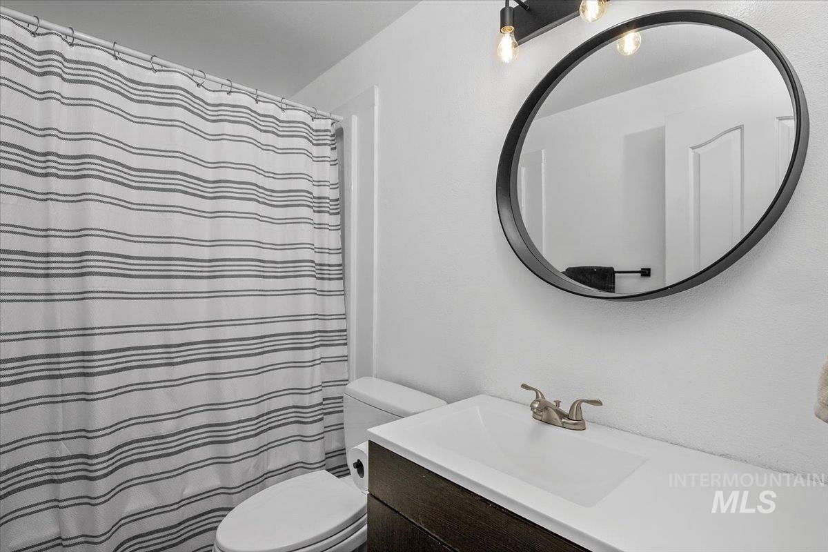 Bathroom featuring a shower with curtain and vanity