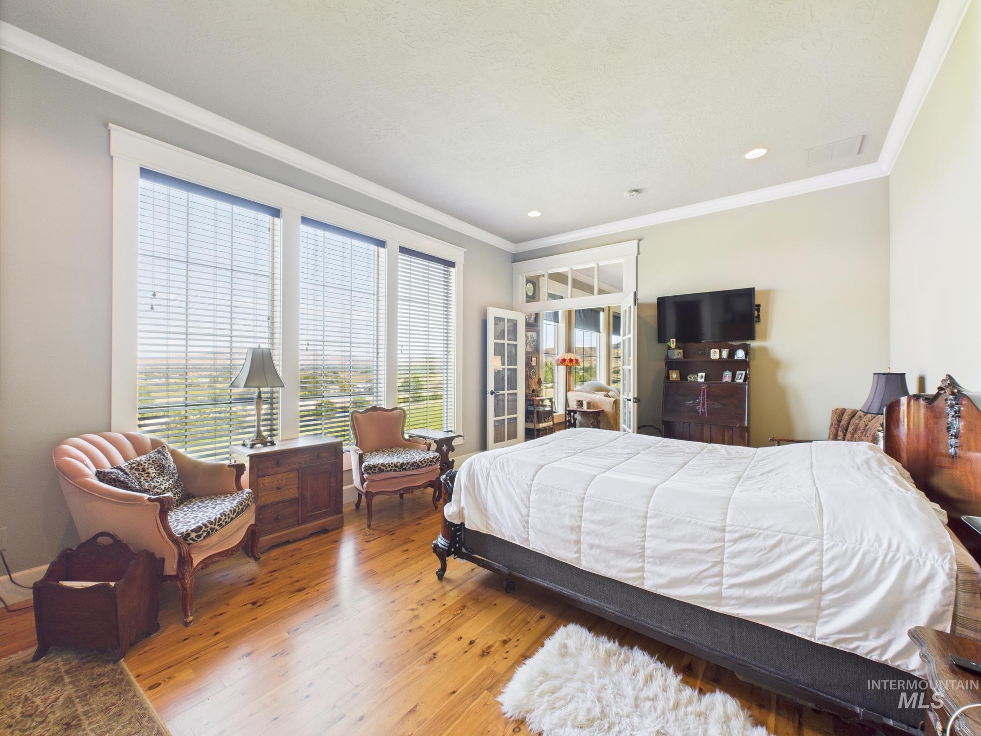 Bedroom featuring ornamental molding and wood finished floors