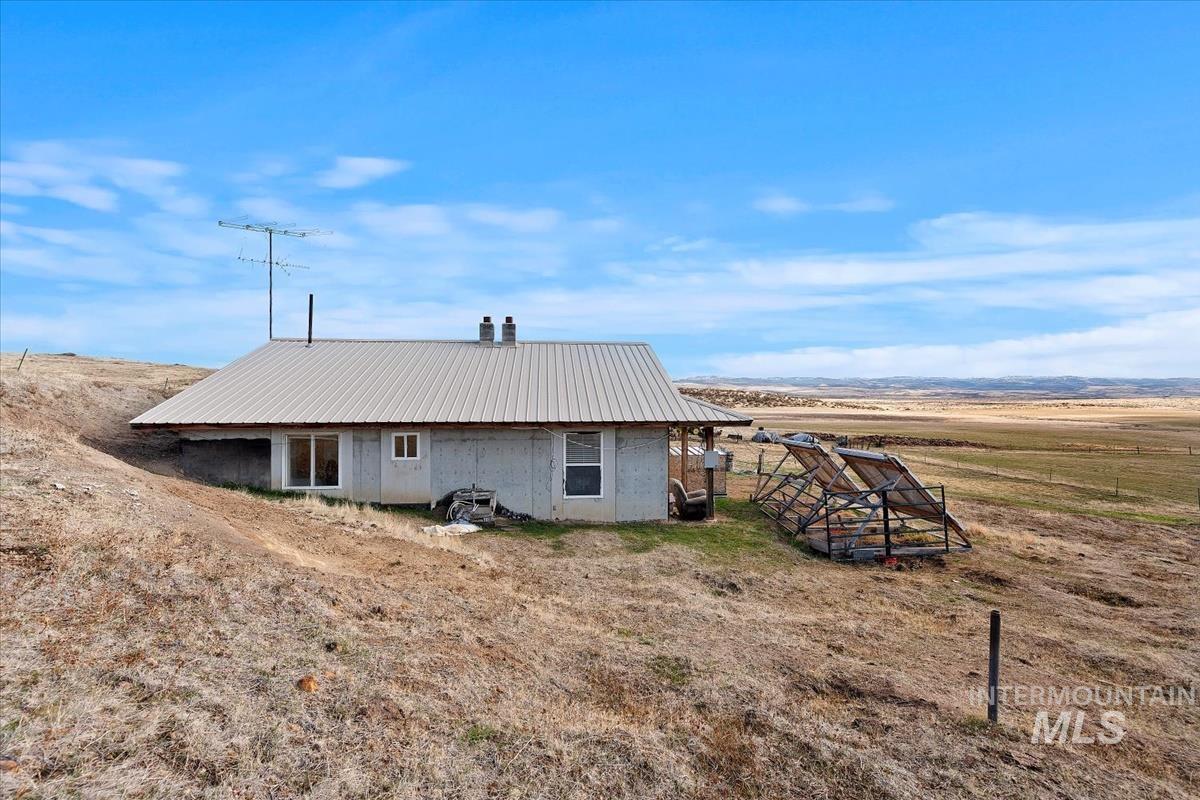 Back of property featuring a metal roof and a view of countryside