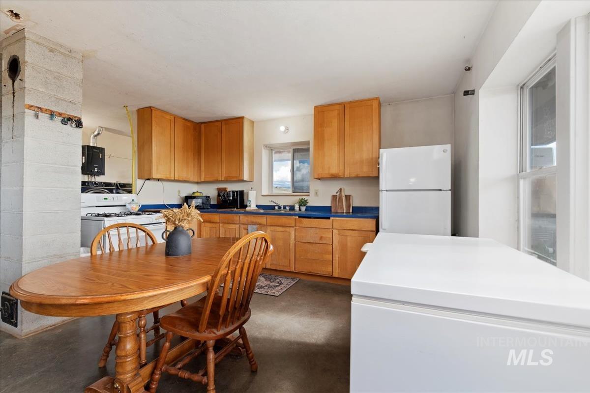Kitchen featuring concrete floors and white appliances