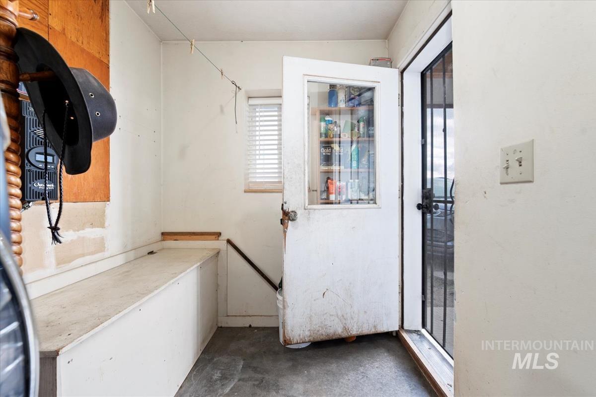 Doorway to outside featuring unfinished concrete floors