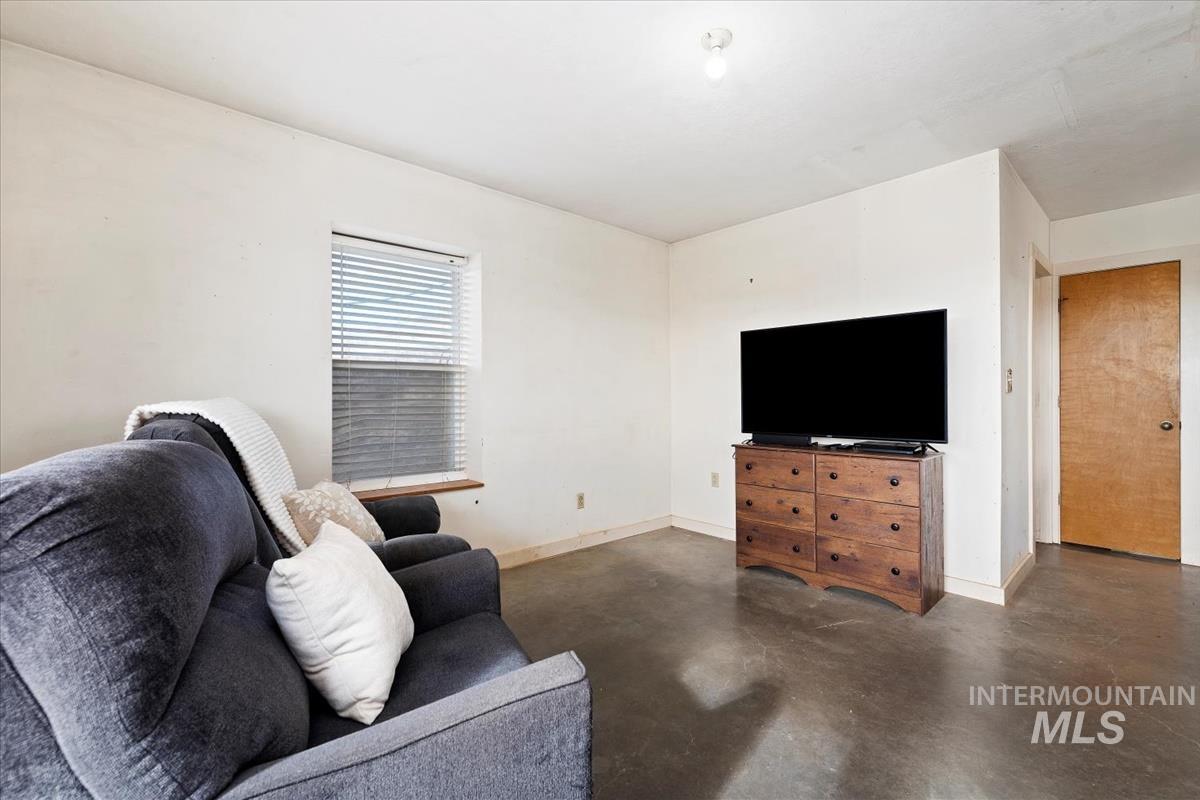 Living room with concrete floors and baseboards